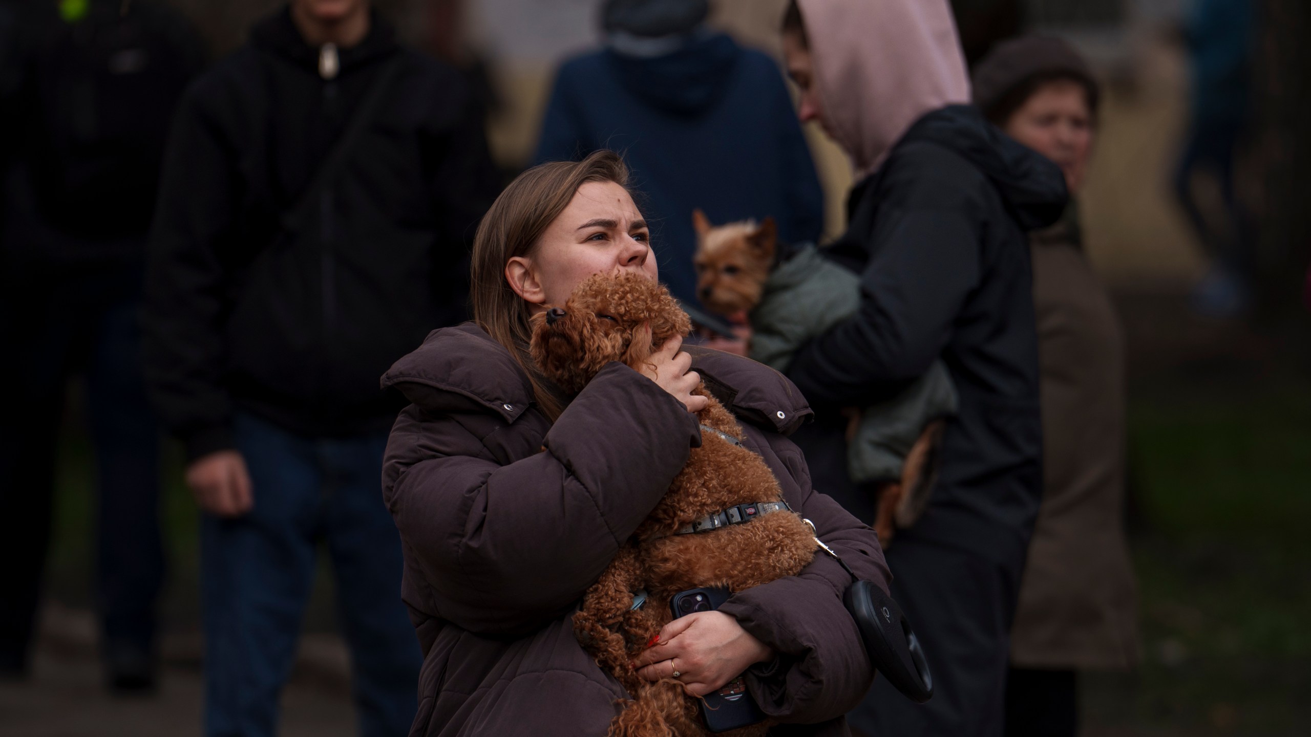 A woman hugs a dog near a bombed building in the Pecherskyi district, after a Russian air attack in Kyiv, Ukraine, Monday March 25, 2024. Several people were injured in the strike. (AP Photo/Vadim Ghirda)