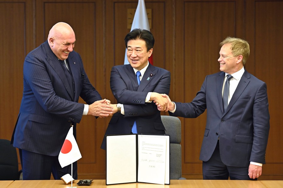 FILE - Britain's Defense Minister Grant Shapps, right, Italy's Defense Minister Guido Crosetto, left, and Japanese Defense Minister Minoru Kihara, center, shake hands after a signing ceremony for the Global Combat Air Programme (GCAP) at the defense ministry, Dec. 14, 2023, in Tokyo, Japan. Japan’s Cabinet on Tuesday, March 26, 2024, approved a plan to sell future next-generation fighter jets that it’s developing with Britain and Italy to other countries, in the latest move away from the country’s postwar pacifist principles. (David Mareuil/Pool Photo via AP, File)