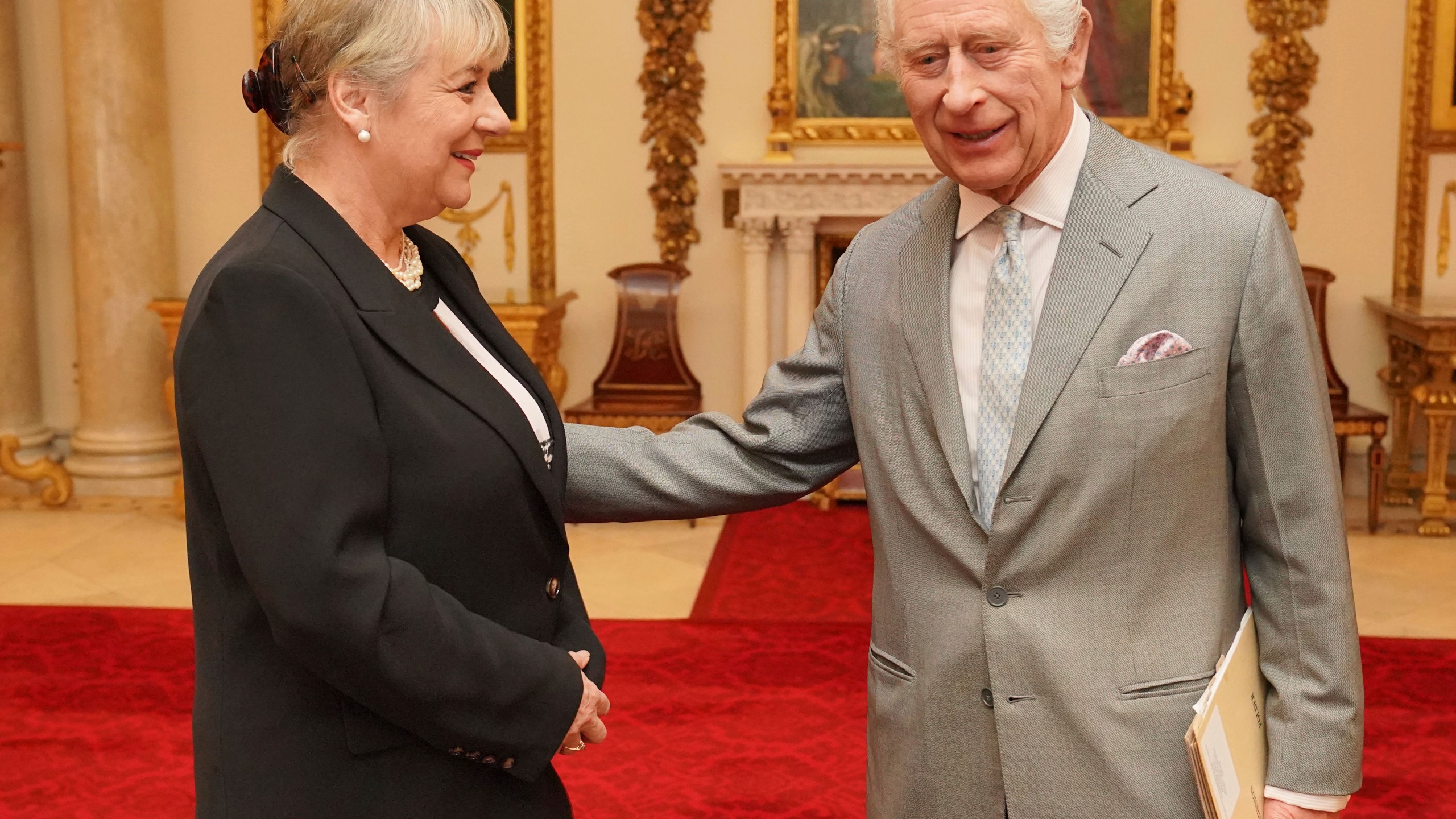 Britain's King Charles III greets Dame Martina Milburn prior to an audience in the Billiard Room at Buckingham Palace, London, on Tuesday March 26, 2024 with community faith leaders from across the UK who have taken part in a Windsor Leadership Trust programme, encouraging and supporting dialogue, harmony and understanding at a time of heightened international tension. (Jonathan Brady, Pool Photo via AP)