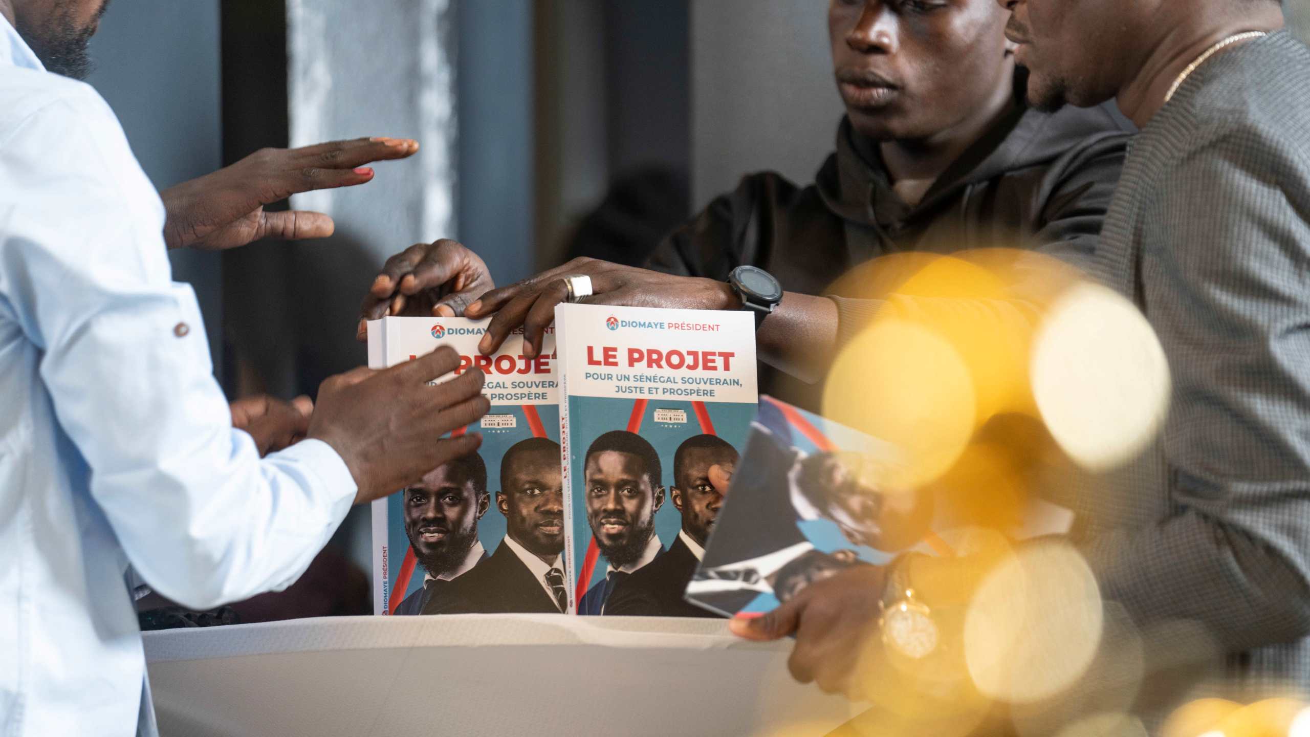 Members of Bassirou Diomaye Faye's campaign display a book called "The Project" as he holds a press conference after winning the presidential elections in Dakar, Senegal, on Monday, March 25, 2024. (AP Photo/Mosa'ab Elshamy)