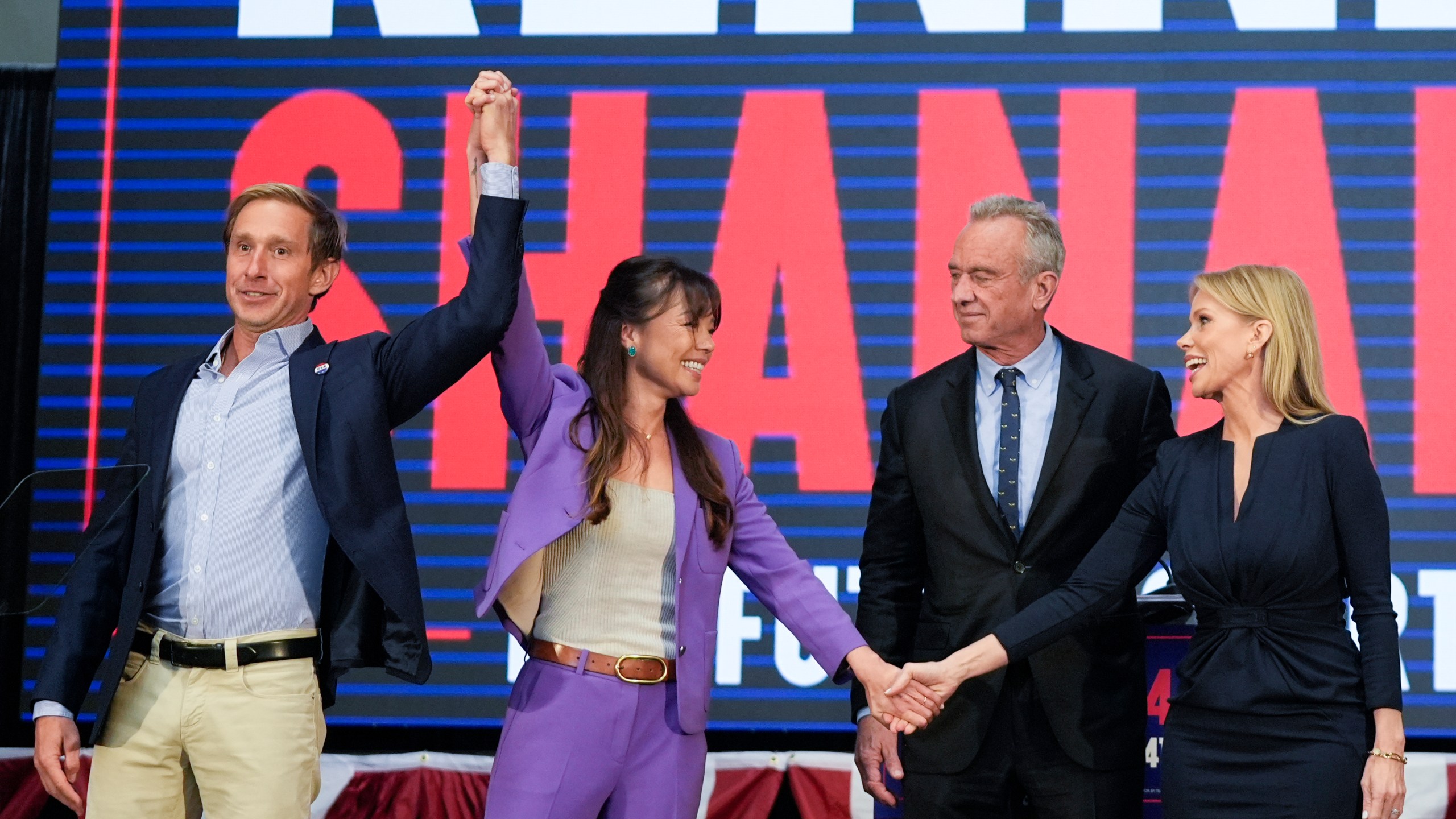 From left, to right, Jacob Strumwasser, Nicole Shanahan, Presidential candidate Robert F. Kennedy Jr. and Cheryl Hines stand together on stage during a campaign event, Tuesday, March 26, 2024, in Oakland, Calif. (AP Photo/Eric Risberg)