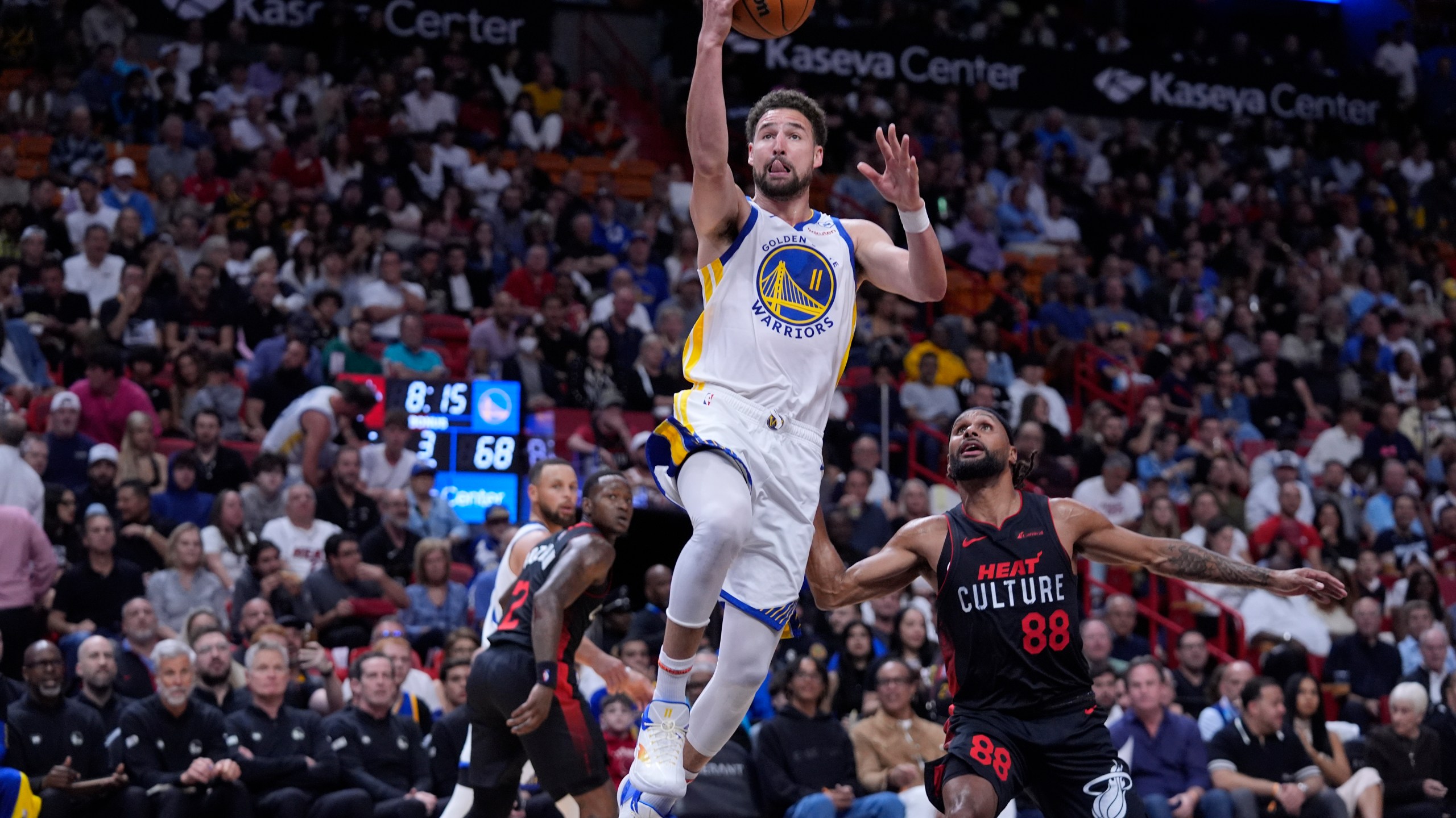 Golden State Warriors guard Klay Thompson (11) goes up for a shot against Miami Heat guard Patty Mills (88) during the second half of an NBA basketball game, Tuesday, March 26, 2024, in Miami. (AP Photo/Wilfredo Lee)