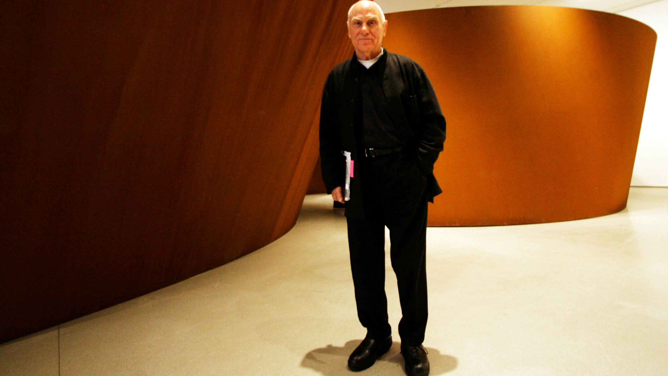 FILE - Famed American sculptor Richard Serra poses for a portrait next to "Sequence" during the press preview of "Richard Serra Sculpture: Forty Years" at the Museum of Modern Art, May 29, 2007, in New York. Serra, known for turning curving walls of rusting steel and other malleable materials into large-scale pieces of outdoor artwork that are now dotted across the world, died Tuesday, March 26, 2024, at his home in Long Island, N.Y. He was 85. (AP Photo/Mary Altaffer, File)