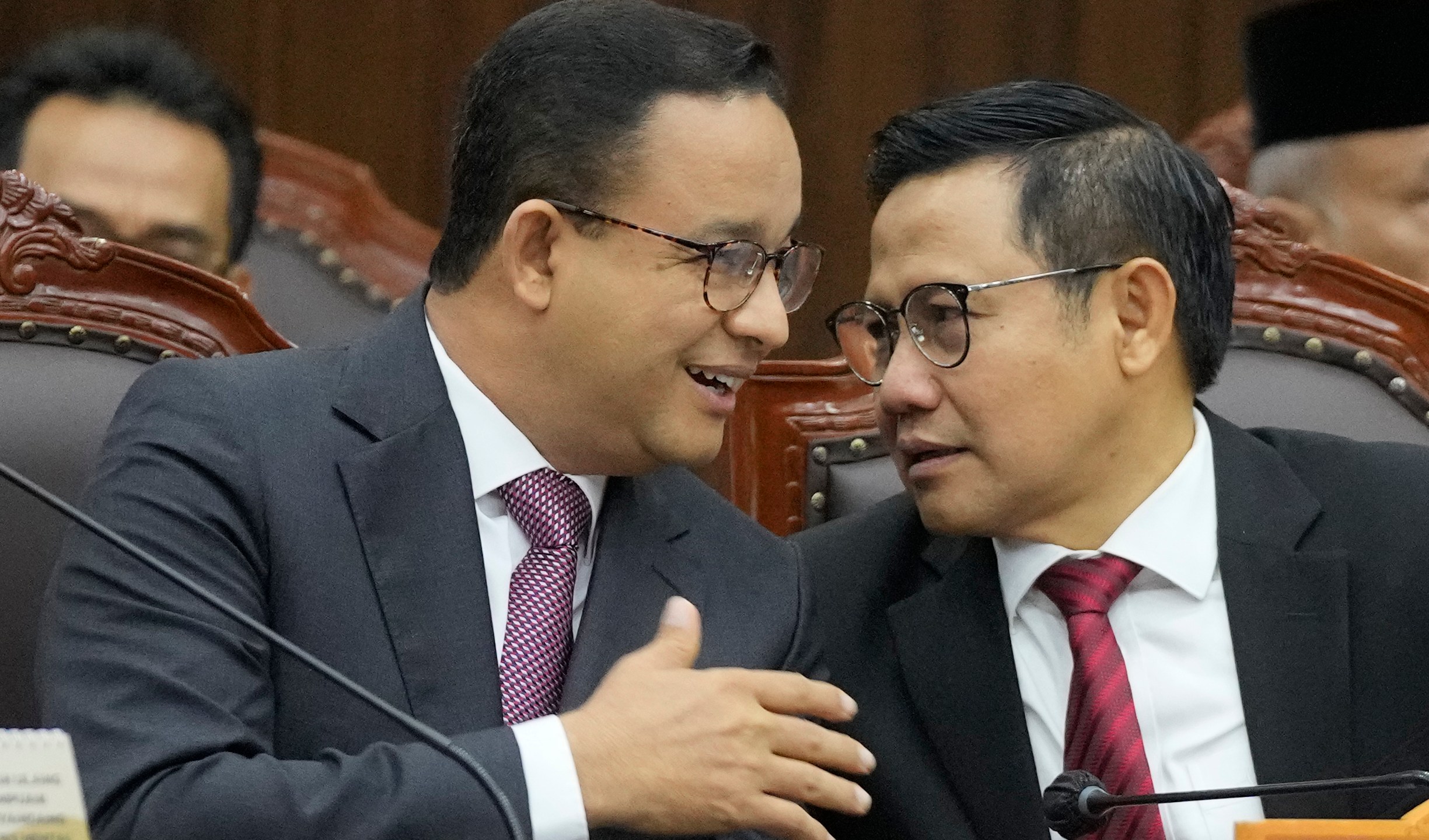 Losing presidential candidate Anies Baswedan, left, talks with his running mate Muhaimin Iskandar during the first hearing of his legal challenge to the Feb. 14 presidential election alleging widespread fraud, at the Constitutional Court in Jakarta, Indonesia, Wednesday, March 27, 2024. Defense Minister Prabowo Subianto, who chose the son of the popular outgoing President Joko Widodo as his running mate, won the election by 58.6% of the votes, according to final results released by the Election Commission. (AP Photo/Dita Alangkara)