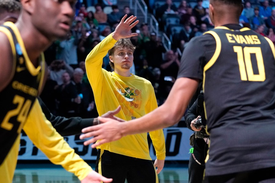 FILE- Oregon's Gabe Reichle, center, greets teammate Kwame Evans Jr. (10) as he is introduced before a college basketball game against Creighton in the second round of the NCAA men's tournament in Pittsburgh, Saturday, March 23, 2024. Reichle orchestrates the pregame handshake for his Oregon teammates. (AP Photo/Gene J. Puskar)