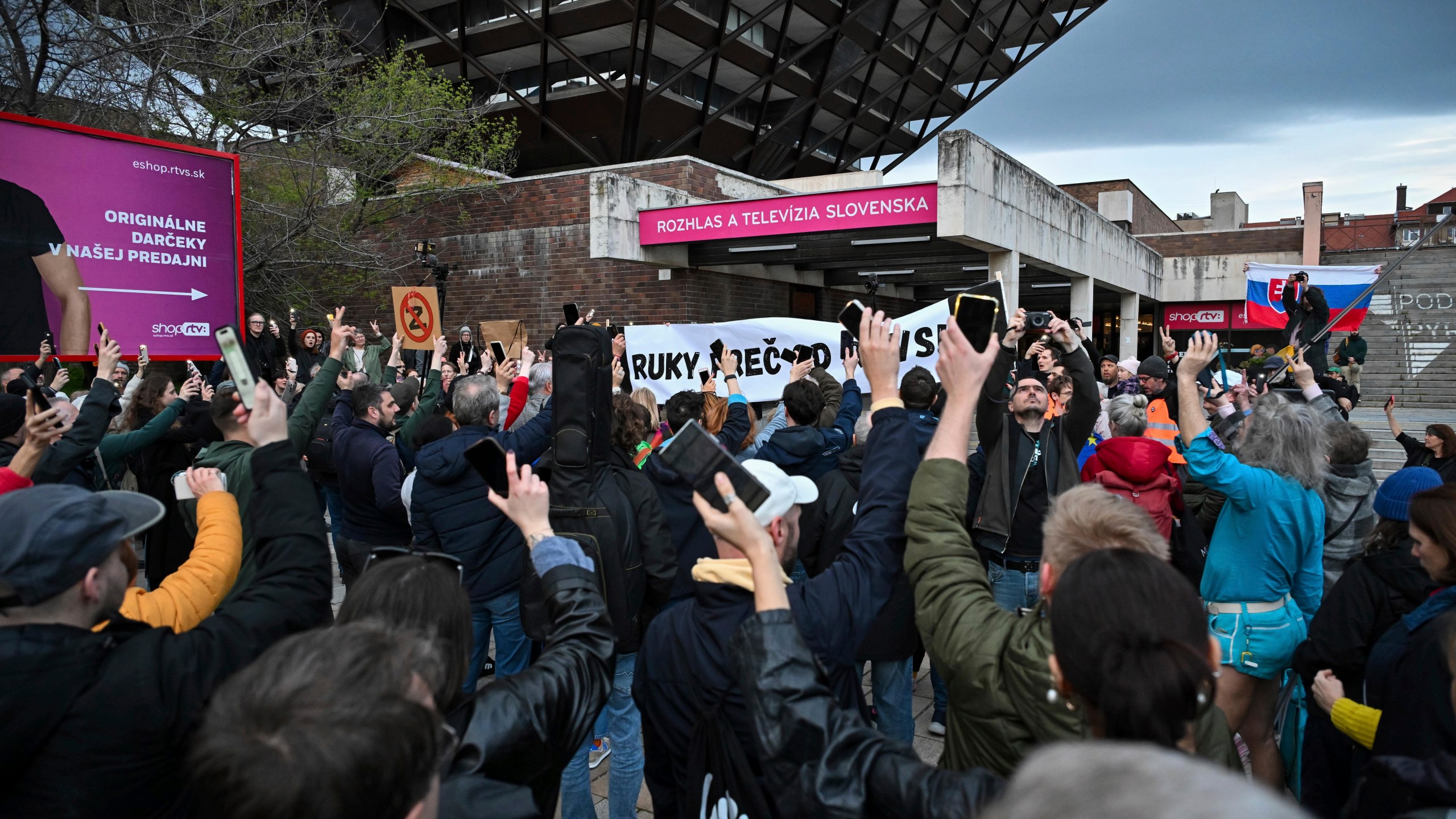 People take part in a protest organised by the Slovakian opposition parties in Bratislava, Wednesday, March. 27, 2024. People in Bratislava have formed a human chain around the building of Slovakia’s public radio and television to protest a plan by the government of populist Prime Minister Robert Fico to take over the broadcasters. The plan has been condemned President Zuzana Čaputová, opposition parties, local journalists, international media organizations, the European Commission and others have warned the changes would give the government’s full control of public broadcasting. (Pavol Zachar/TASR via AP)