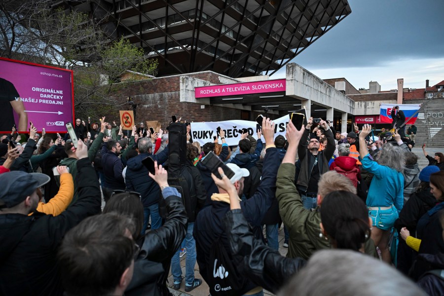 People take part in a protest organised by the Slovakian opposition parties in Bratislava, Wednesday, March. 27, 2024. People in Bratislava have formed a human chain around the building of Slovakia’s public radio and television to protest a plan by the government of populist Prime Minister Robert Fico to take over the broadcasters. The plan has been condemned President Zuzana Čaputová, opposition parties, local journalists, international media organizations, the European Commission and others have warned the changes would give the government’s full control of public broadcasting. (Pavol Zachar/TASR via AP)