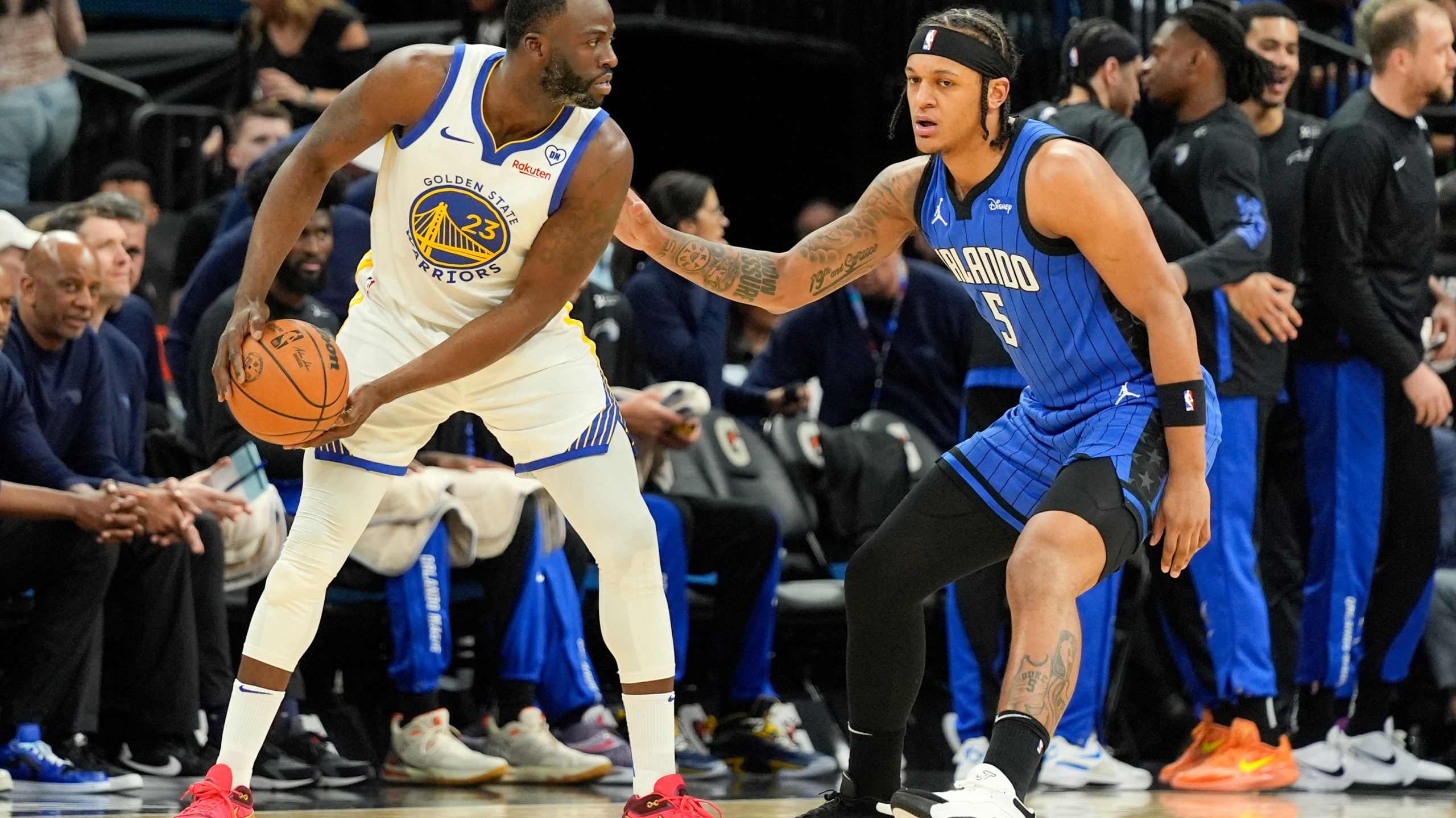 Golden State Warriors forward Draymond Green (23) looks for an opening as Orlando Magic forward Paolo Banchero (5) defends during the first half of an NBA basketball game Wednesday, March 27, 2024, in Orlando, Fla. (AP Photo/John Raoux)
