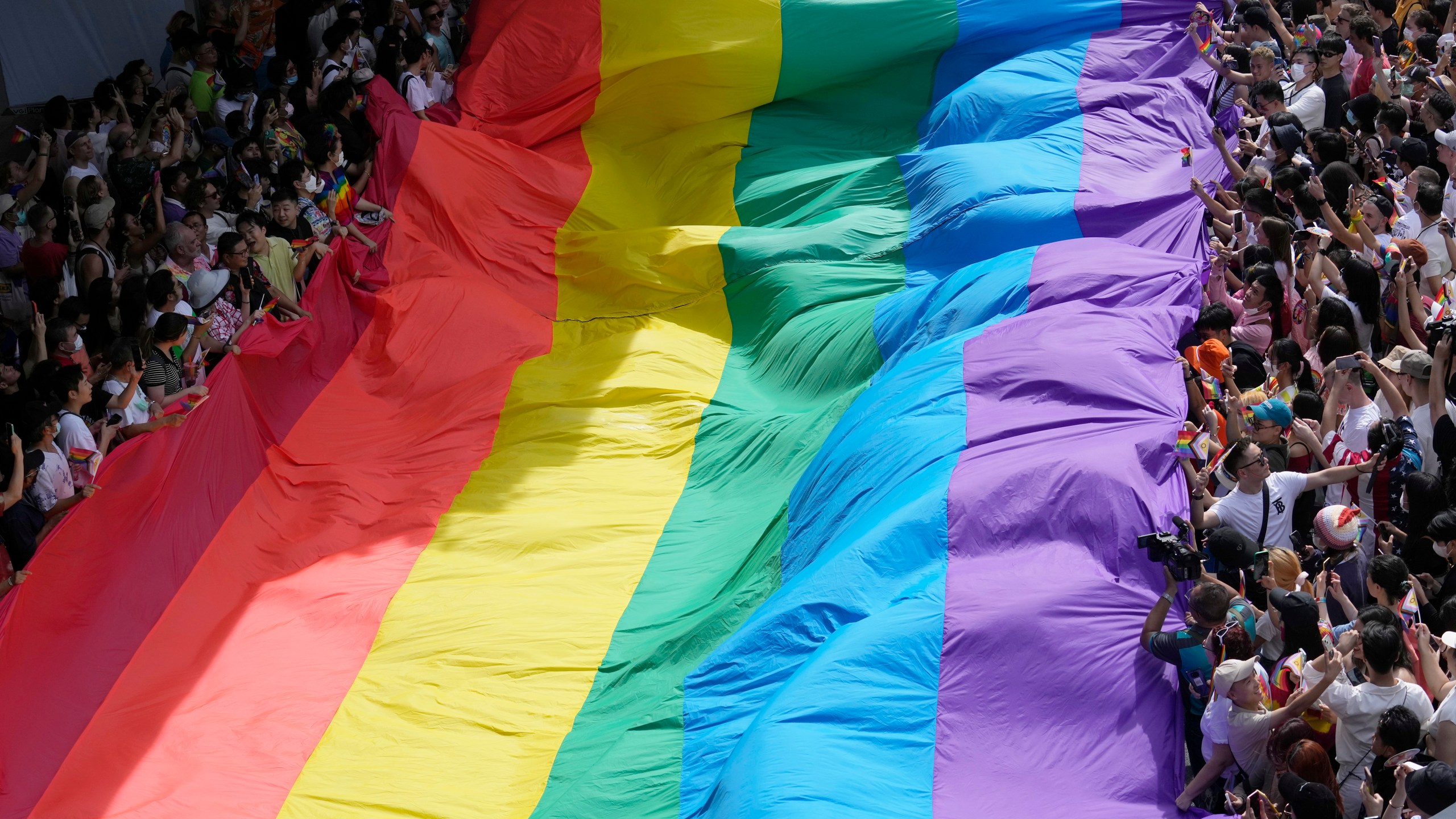FILE - Participants hold a rainbow flag during a Pride Parade in Bangkok, Thailand, on June 4, 2023. Lawmakers in Thailand's lower house of Parliament overwhelmingly approved a marriage equality bill on Wednesday, March 27, 2024, that would make the country the first in Southeast Asia to legalize equal rights for marriage partners of any gender. (AP Photo/Sakchai Lalit, File)