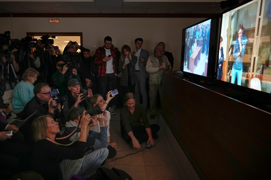 FILE - Journalists watch a televised court hearing on Wall Street Journal reporter Evan Gershkovich in Moscow, Russia, on Tuesday, April 18, 2023. Gershkovich is a U.S. citizen and has been jailed in Russia for a year on charges of espionage, which he, his employer and the U.S. government all deny. (AP Photo/Alexander Zemlianichenko, File)