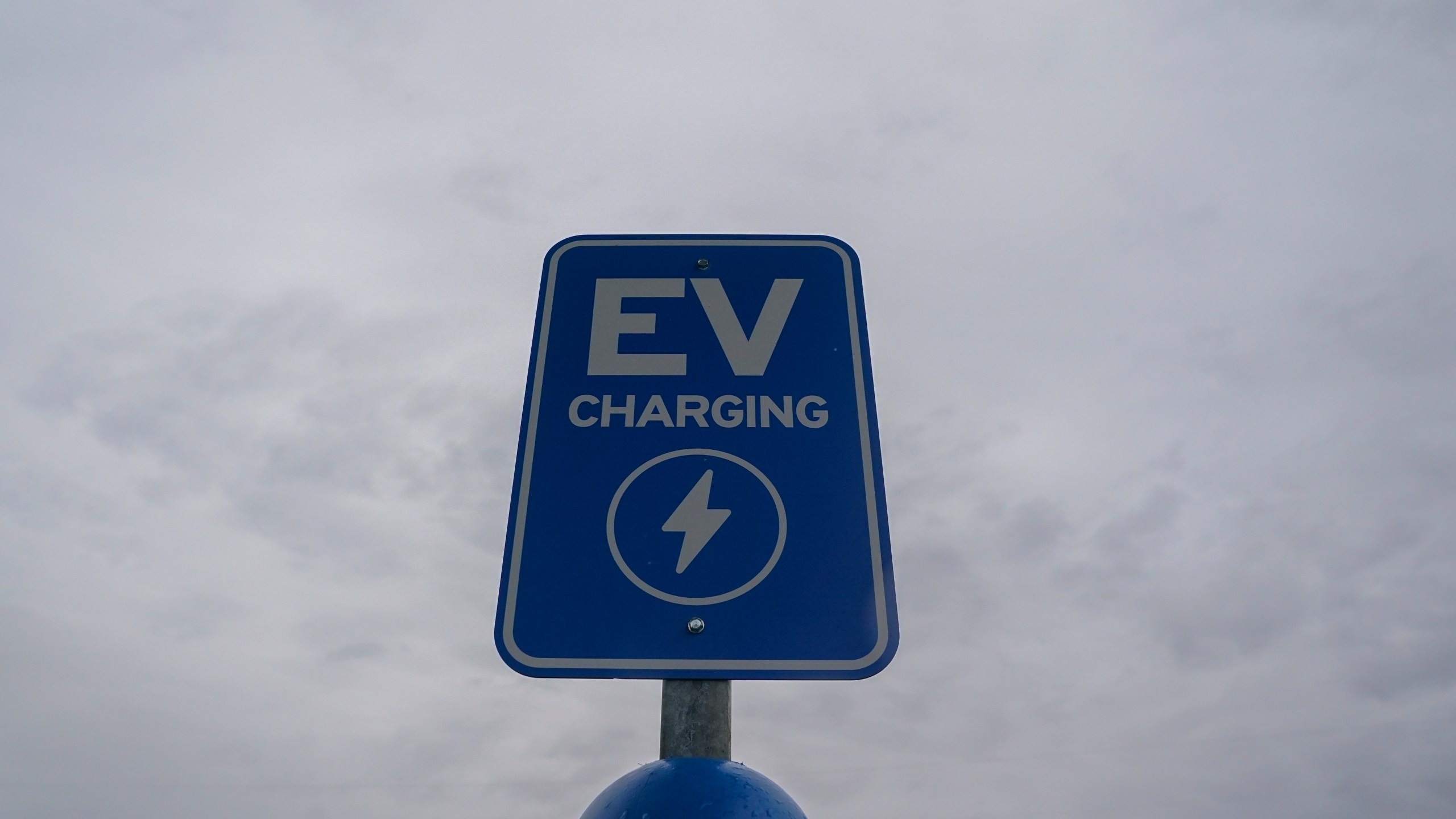 A sign sits at an electric vehicle charging station, Friday, March 8, 2024, at an electric vehicle charging station in London, Ohio. The charging ports are a key part of President Joe Biden’s effort to encourage drivers to move away from gasoline-powered cars and trucks that contribute to global warming. (AP Photo/Joshua A. Bickel)