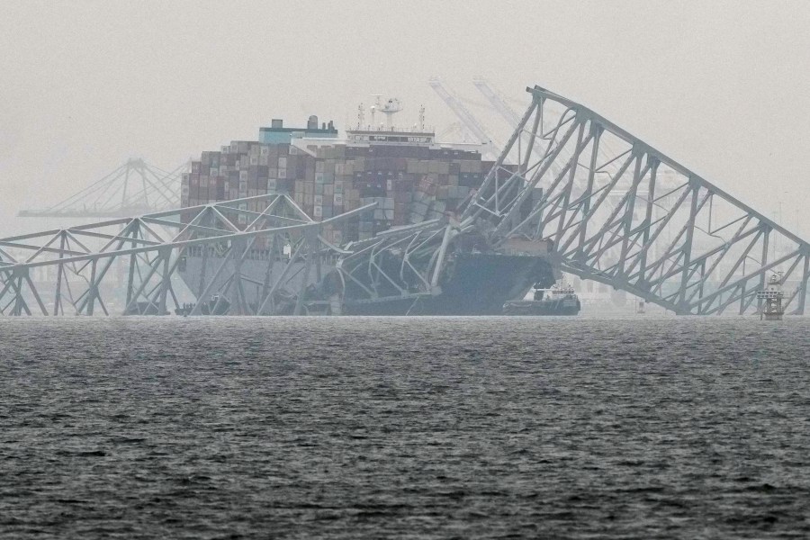 A container ship rests against the wreckage of the Francis Scott Key Bridge on Thursday, March 28, 2024, in Baltimore, Md. After days of searching through murky water for the workers missing after the bridge collapsed, officials are turning their attention Thursday to what promises to be a massive salvage operation. (AP Photo/Matt Rourke)