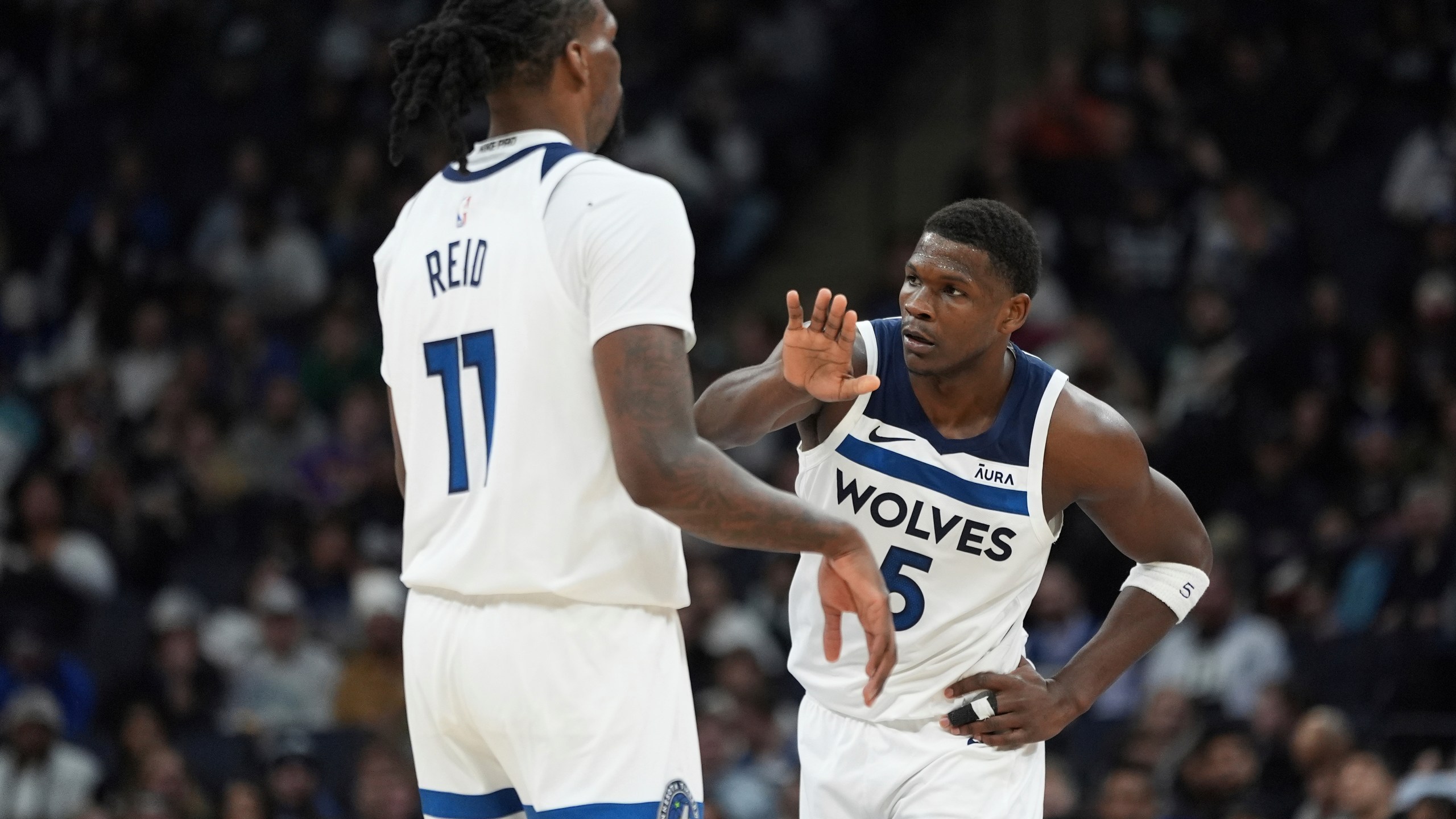 Minnesota Timberwolves center Naz Reid (11) and guard Anthony Edwards (5) high-five during the second half of an NBA basketball game against the Detroit Pistons, Wednesday, March 27, 2024, in Minneapolis. (AP Photo/Abbie Parr)