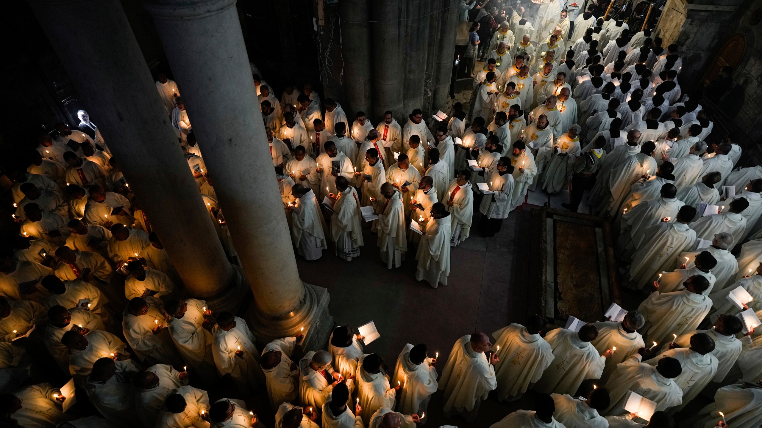 Catholic clergy hold candles as they walk during the Washing of the Feet procession at the Church of the Holy Sepulcher, where many Christians believe Jesus was crucified, buried, and rose from the dead, in the Old City of Jerusalem, Thursday, March 28, 2024. (AP Photo/Ohad Zwigenberg)