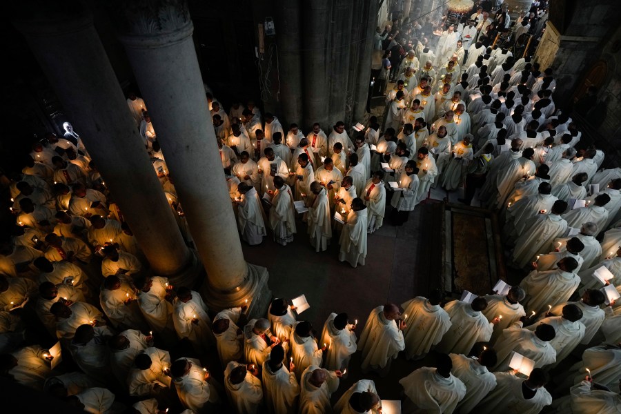 Catholic clergy hold candles as they walk during the Washing of the Feet procession at the Church of the Holy Sepulcher, where many Christians believe Jesus was crucified, buried, and rose from the dead, in the Old City of Jerusalem, Thursday, March 28, 2024. (AP Photo/Ohad Zwigenberg)