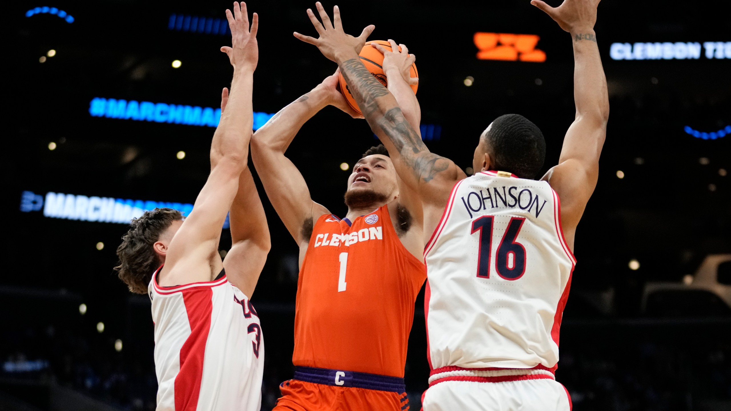 Clemson guard Chase Hunter (1) drives to the basket between Arizona guard Pelle Larsson (3) and forward Keshad Johnson (16) during the first half of a Sweet 16 college basketball game in the NCAA tournament Thursday, March 28, 2024, in Los Angeles. (AP Photo/Ashley Landis)
