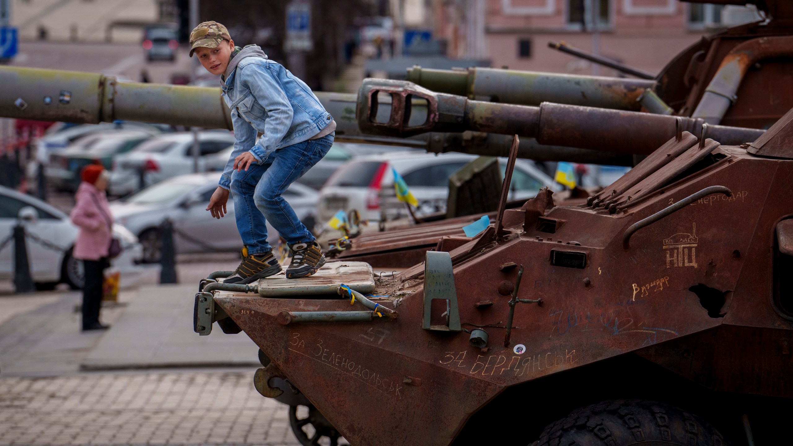 A child climbs on a rusty armored personnel carrier, part of a display of destroyed Russian military equipment in Kyiv, Ukraine, Thursday, March 28, 2024. (AP Photo/Vadim Ghirda)