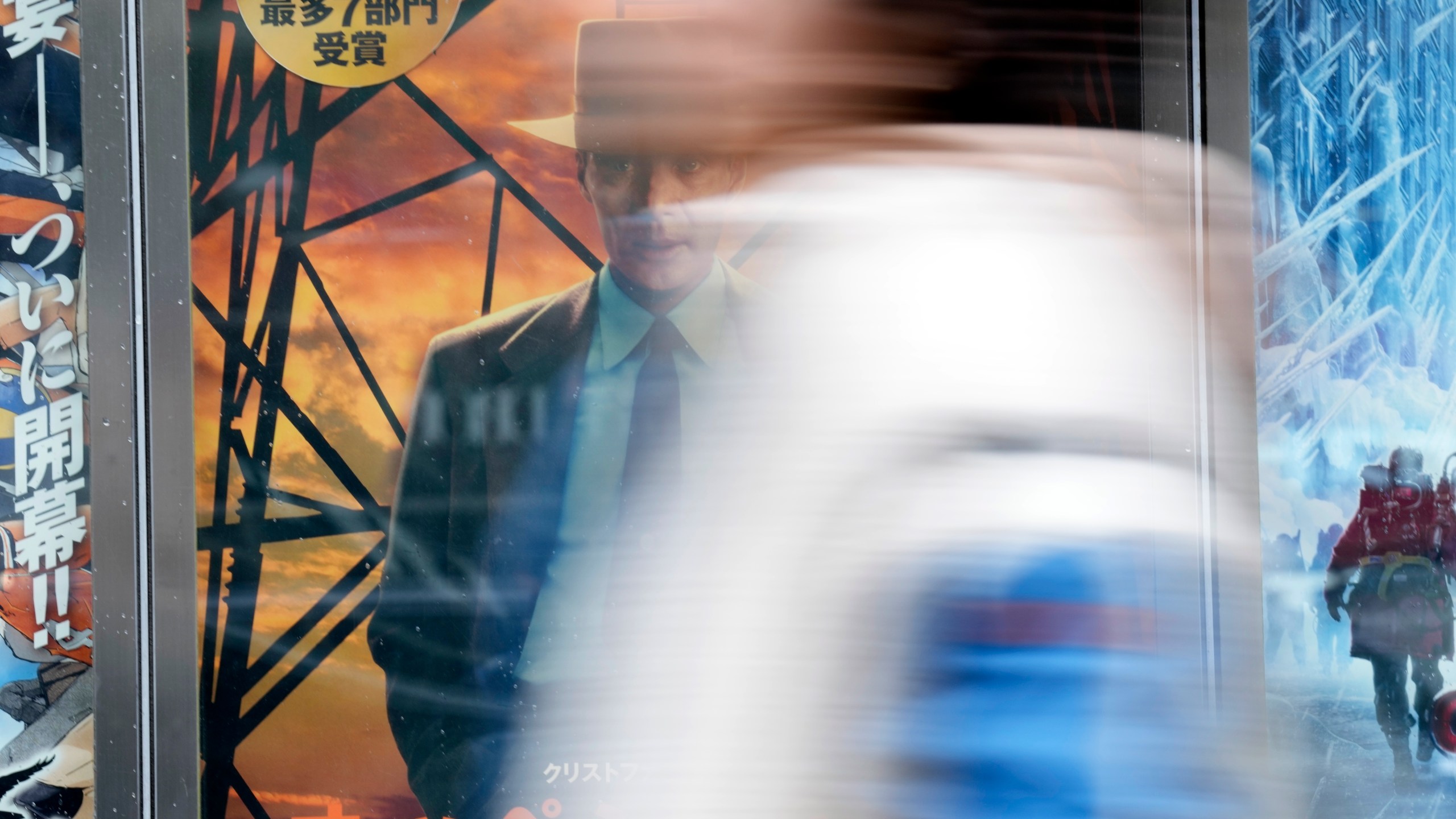 A person stands in front of the advertisements of films on showing at a movie theater including the seven Academy Award winning movie "Oppenheimer" Friday, March 29, 2024, in Tokyo. “Oppenheimer” finally premiered Friday in the nation where two cities were obliterated 79 years ago by the nuclear weapons invented by the American scientist who was the subject of the Oscar-winning film. Japanese filmgoers' reactions understandably were mixed and highly emotional. (AP Photo/Eugene Hoshiko)