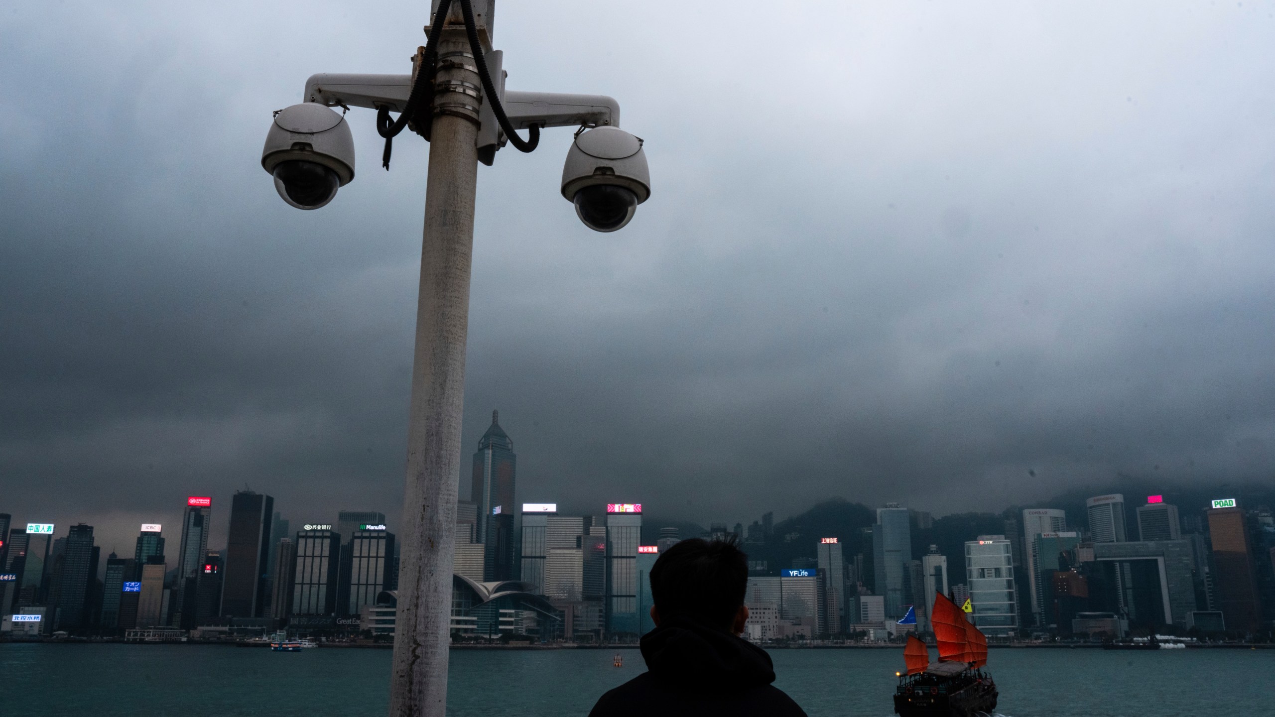 FILE - Surveillance cameras are seen as a visitor looks at Victoria Harbour in Hong Kong, Monday, March 11, 2024. The president of U.S.-funded Radio Free Asia said its Hong Kong bureau has been closed because of safety concerns under a new national security law, deepening concerns about the city’s media freedoms. Bay Fang, the president of RFA, said in a statement Friday March 29, 2024 that it will no longer have full-time staff in Hong Kong, although it would retain its official media registration. (AP Photo/Louise Delmotte, File)