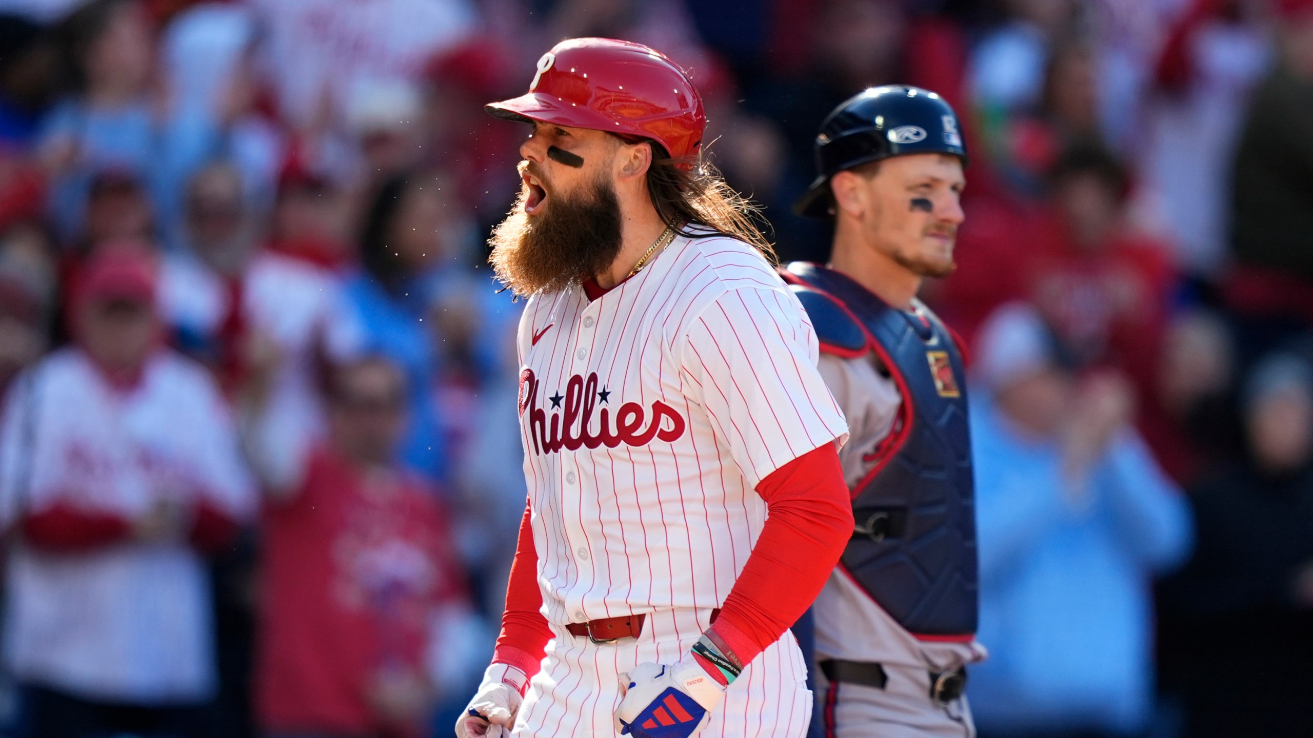 Philadelphia Phillies' Brandon Marsh, left, reacts past Atlanta Braves catcher Sean Murphy after hitting a two-run home run against pitcher Spencer Strider during the fifth inning of an opening-day baseball game, Friday, March 29, 2024, in Philadelphia. (AP Photo/Matt Slocum)