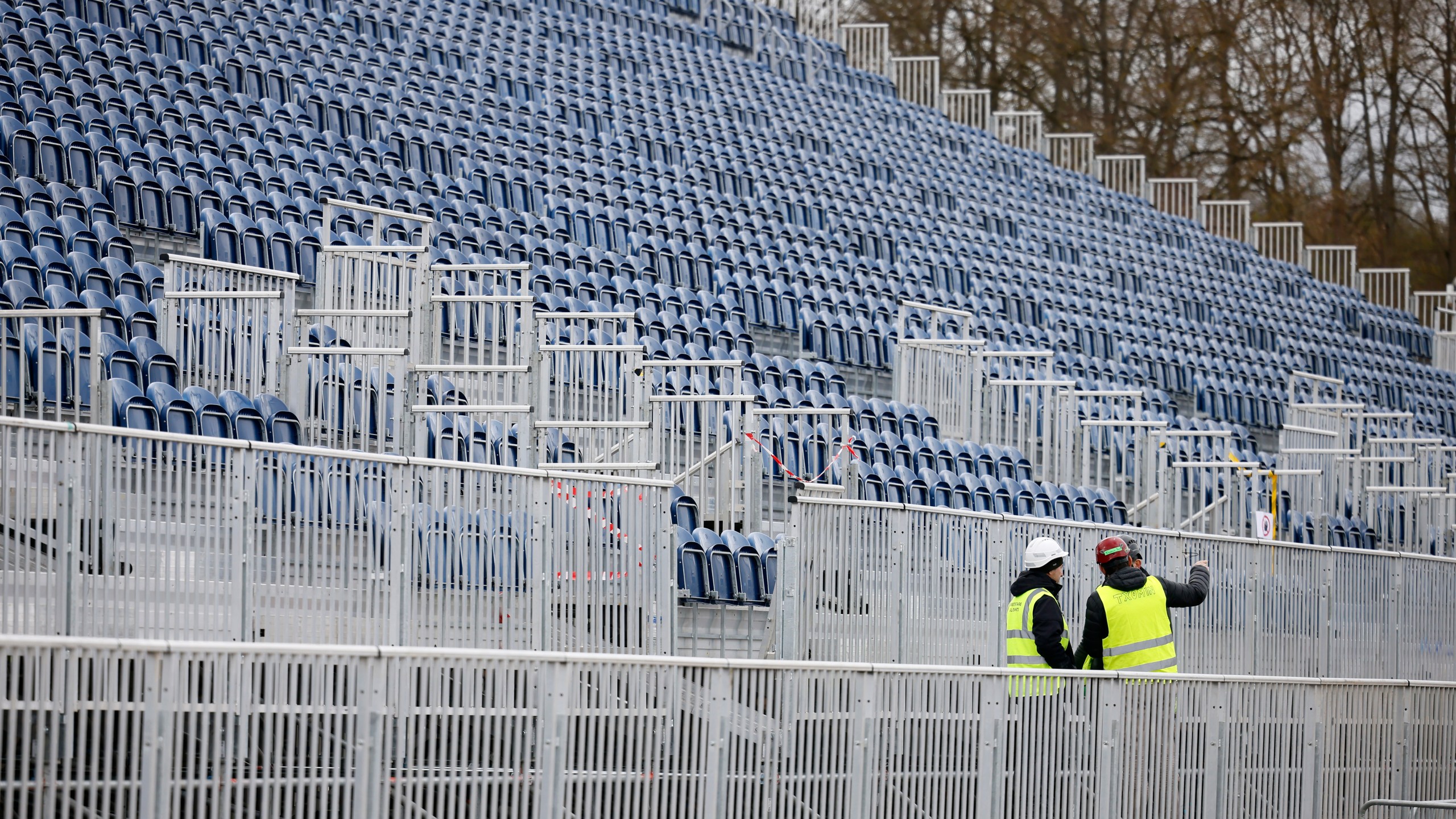 Workers discuss in the stands to watch the equestrian sports, Friday, March 29, 2024 in the park of the Chateau de Versailles, west of Paris. The site will be the venue for equestrian sports at the Paris 2024 Olympic Games. (AP Photo/Thomas Padilla)