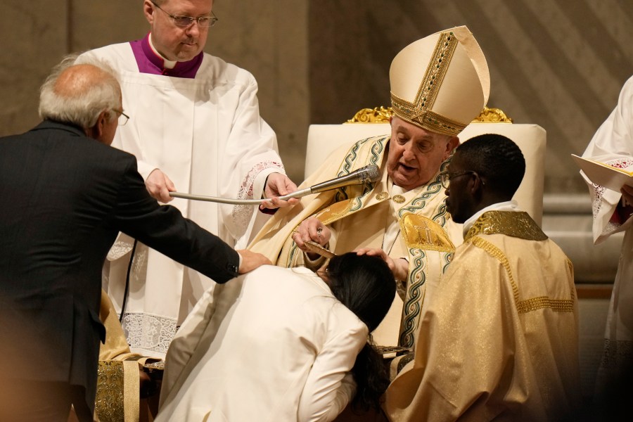 Pope Francis baptises a faithful as he presides over the Easter vigil celebration in St. Peter's Basilica at the Vatican, Saturday, March 30, 2024. (AP Photo/Alessandra Tarantino)