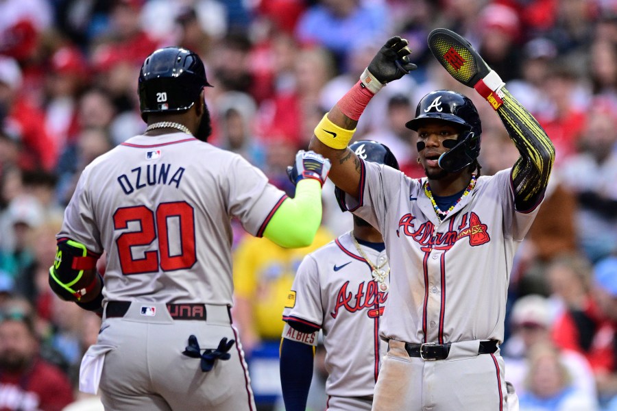 Atlanta Braves' Ronald Acuna Jr., right, high fives Marcell Ozuna (20) after Ozuna hit a three-run home run during the sixth inning of a baseball game against the Philadelphia Phillies, Saturday, March 30, 2024, in Philadelphia. (AP Photo/Derik Hamilton)