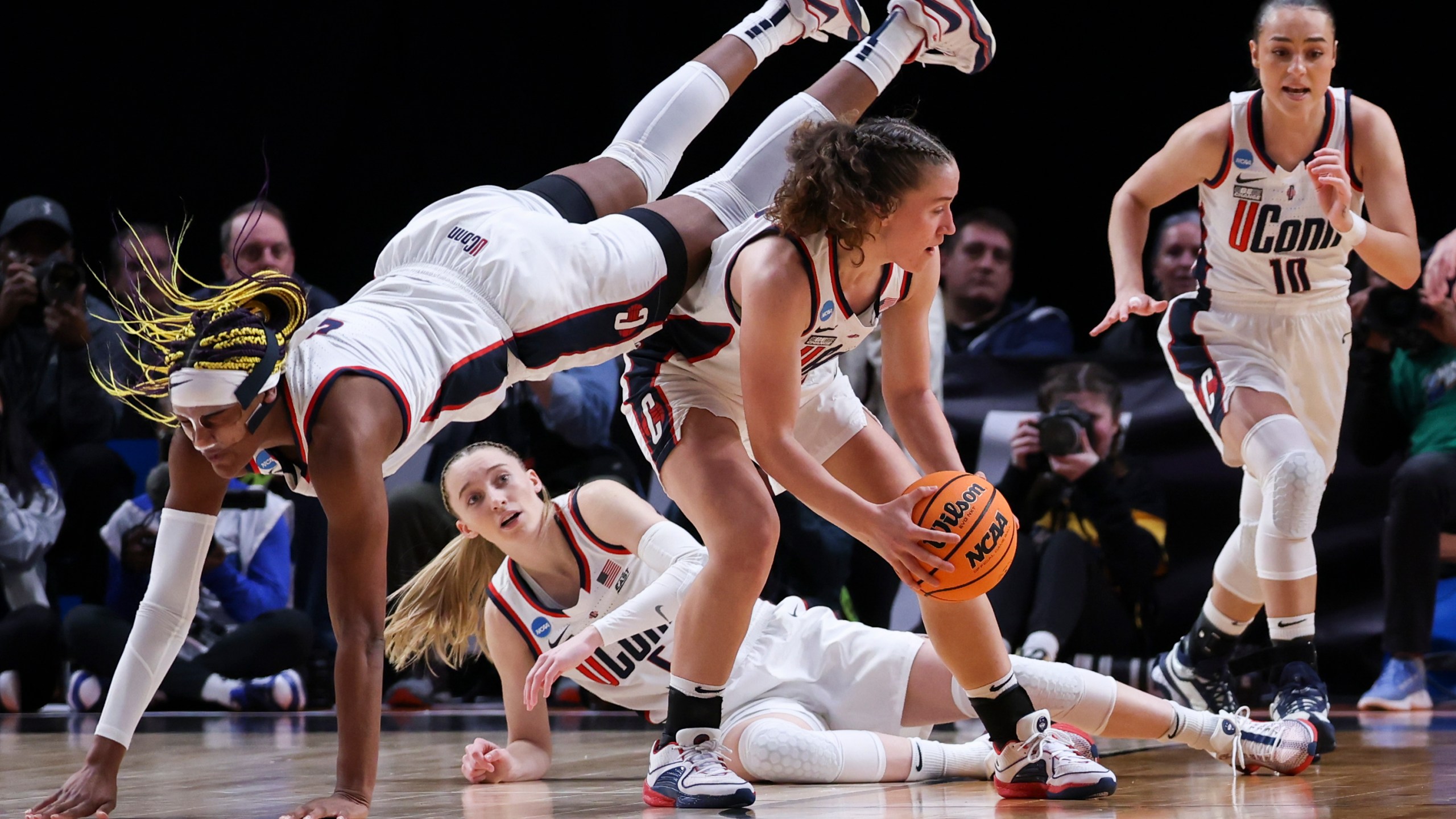 UConn forward Aaliyah Edwards, left, dives over UConn guard Ashlynn Shade during the first half of the team's Sweet 16 college basketball game against Duke in the women's NCAA Tournament, Saturday, March 30, 2024, in Portland, Ore. (AP Photo/Howard Lao)