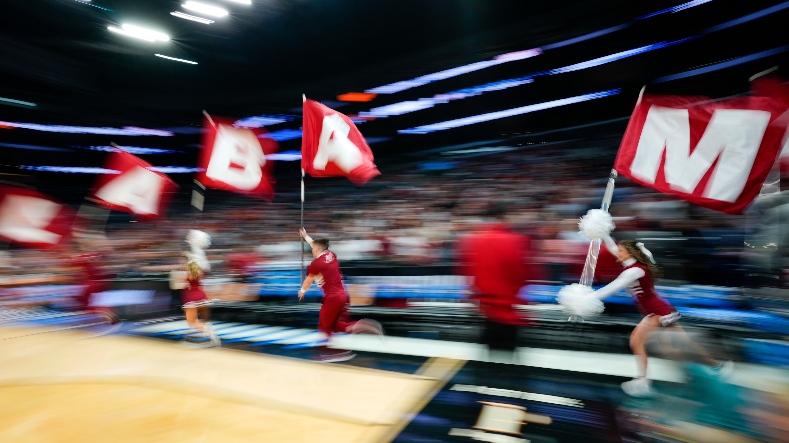 Alabama cheerleaders run onto the court before an Elite 8 college basketball game against Clemson in the NCAA tournament Saturday, March 30, 2024, in Los Angeles. (AP Photo/Ashley Landis)