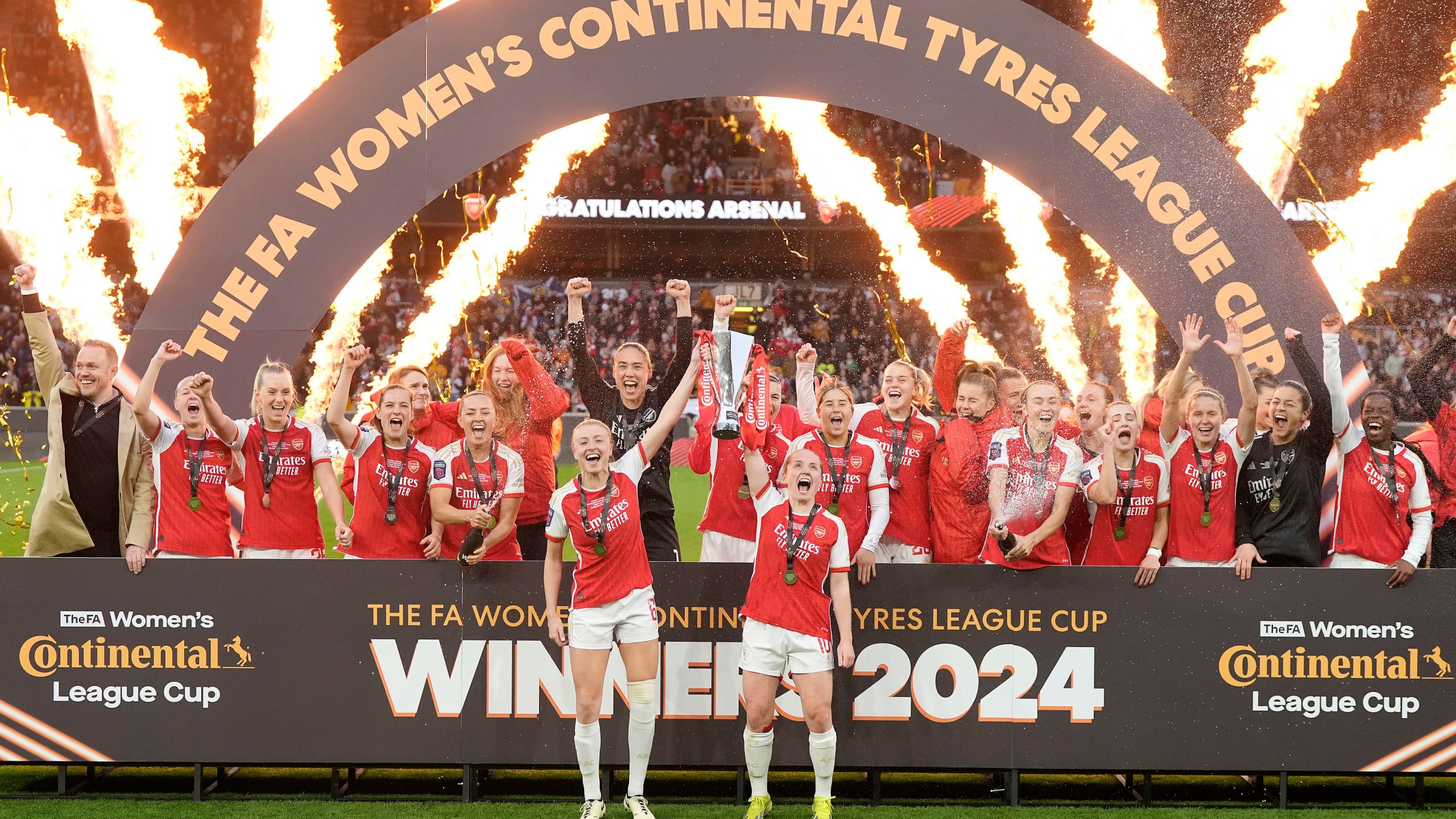 Arsenal's Leah Williamson, front left, and Kim Little, front right, lift the trophy after winning the FA Women's Continental Tyres League Cup Final soccer match between Arsenal and Chelsea at Molineux Stadium, Wolverhampton, England, Sunday March 31, 2024. (Nick Potts/PA via AP)