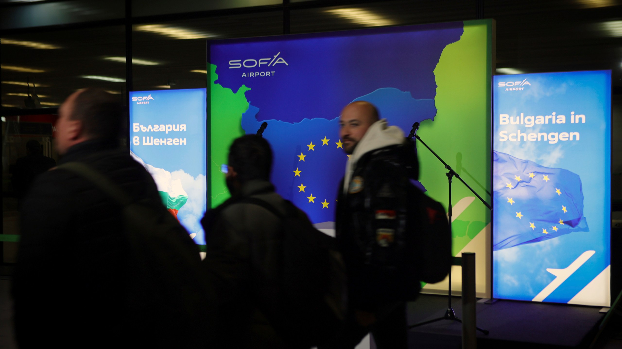 Passengers pass posters announcing Bulgarias' accession in Schengen by air and water, at Sofia airport, Bulgaria, Sunday, March 31, 2024. Romania and Bulgaria partially joined Europe's ID-check-free travel zone on Sunday, marking a new step in the two countries' integration with the European Union. AP Photo/Valentina Petrova)