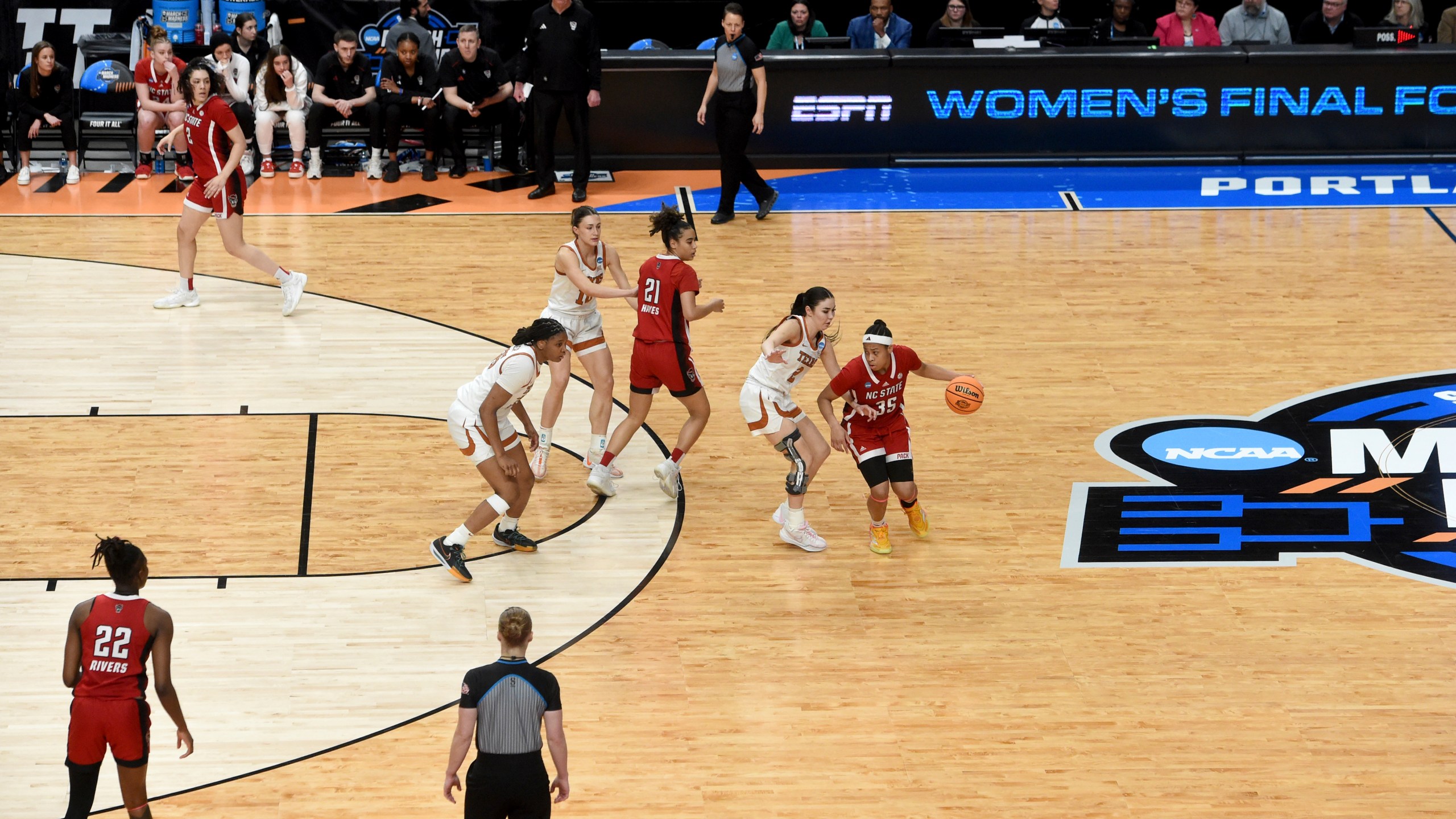 North Carolina State guard Zoe Brooks, right, dribbles the ball against Texas guard Shaylee Gonzales, second from right, at the top of the three-point line during the second half of a Elite Eight college basketball game in the NCAA Tournament, Sunday, March 31, 2024, in Portland, Ore. (AP Photo/Steve Dykes)