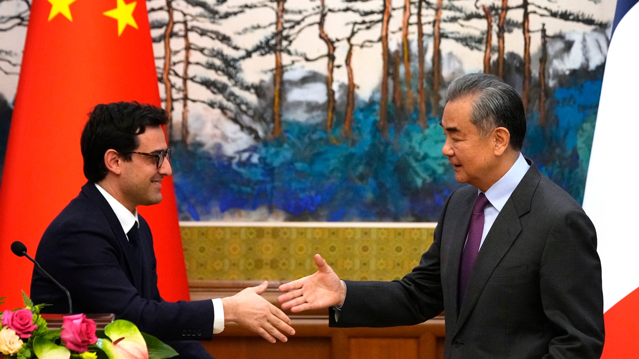 Chinese Foreign Minister Wang Yi, right, shakes hands with French Foreign Minister Stephane Sejourne, left, after a joint press conference at the Diaoyutai State Guesthouse in Beijing, China, Monday, April 1, 2024. (Ken Ishii/Pool Photo via AP)
