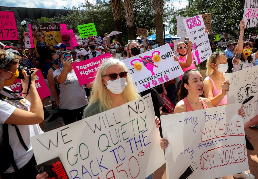 FILE - Participants wave signs as they walk back to Orlando City Hall during the March for Abortion Access, Oct. 2, 2021, in Orlando, Fla. The Florida Supreme Court on Monday, April 1, 2024, upheld the state's ban on most abortions after 15 weeks of pregnancy, which means a subsequently passed six-week ban can soon take effect. (Chasity Maynard/Orlando Sentinel via AP, File)