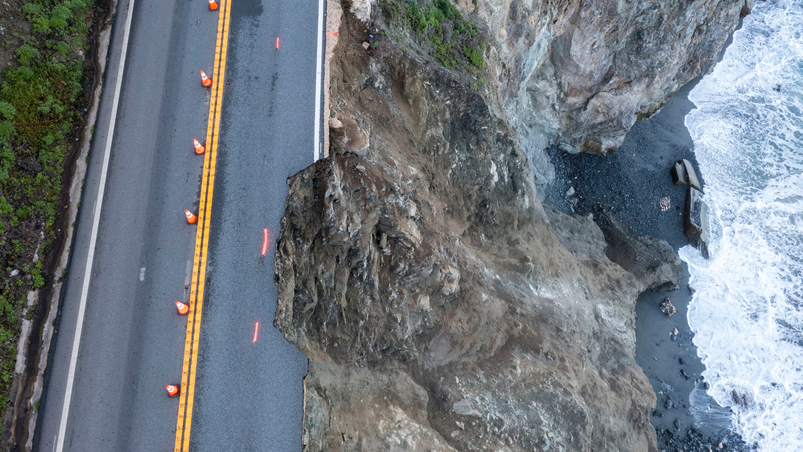 Cones mark a break in the southbound lane of Highway 1 at Rocky Creek Bridge in Big Sur, Calif., Monday, April 1, 2024, following an Easter weekend storm. (AP Photo/Nic Coury)