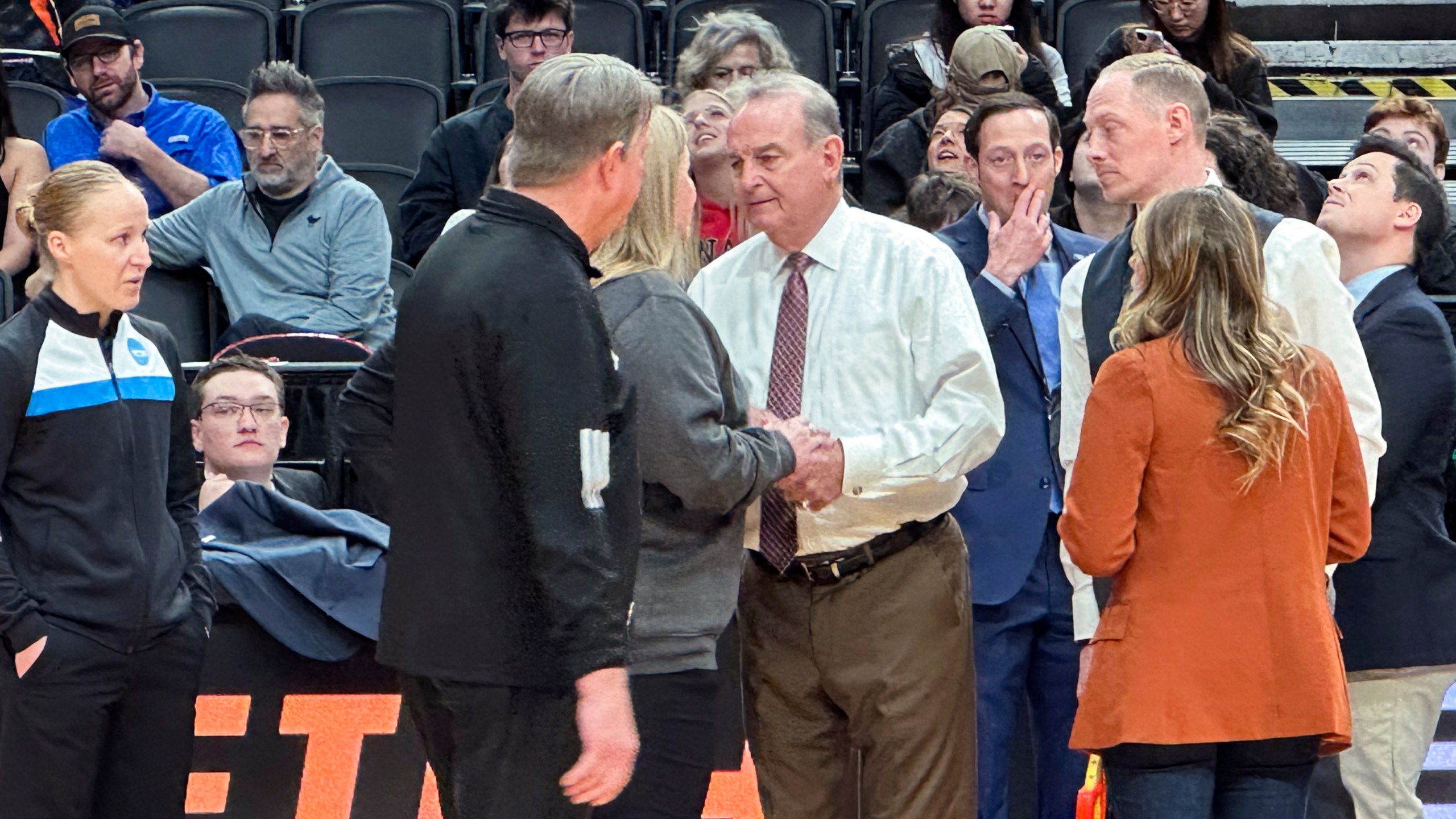 Texas head coach Vic Schaefer, center right, talks to officials before an Elite Eight college basketball game against North Carolina State in the women's NCAA Tournament, Sunday, March 31, 2024, in Portland, Ore. The 3-point line for the women's NCAA Tournament at Moda Center had a discrepancy in distance at each end of the court that went unnoticed through four games over two days before Texas and North Carolina State were informed of the problem ahead of their Elite Eight matchup on Sunday. (AP Photo/Anne Peterson)