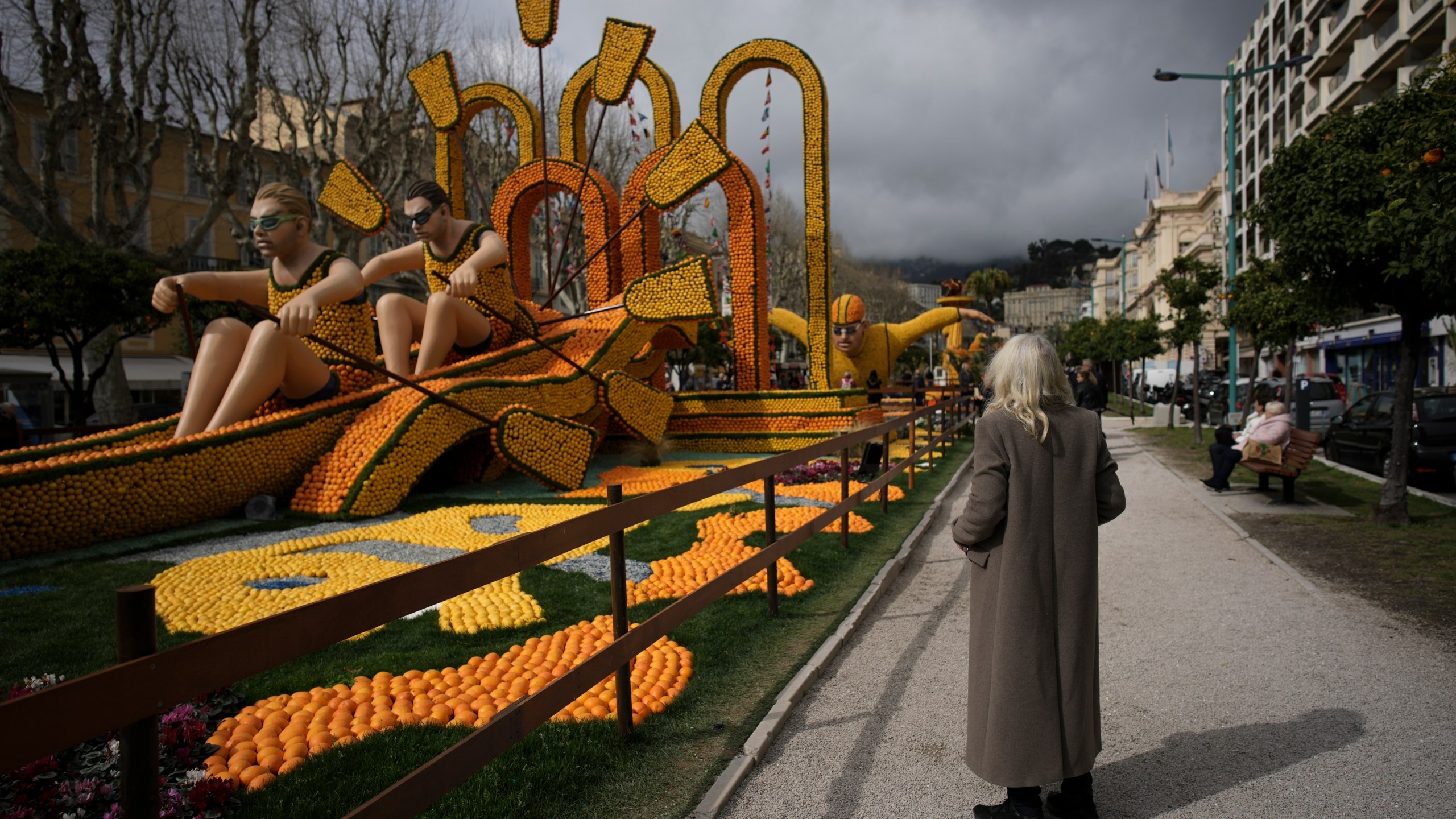 A visitor examines a sculpture made of lemons during the 90th edition of the Lemon Festival in Menton, France, Friday, March 1, 2024. (AP Photo/Daniel Cole)