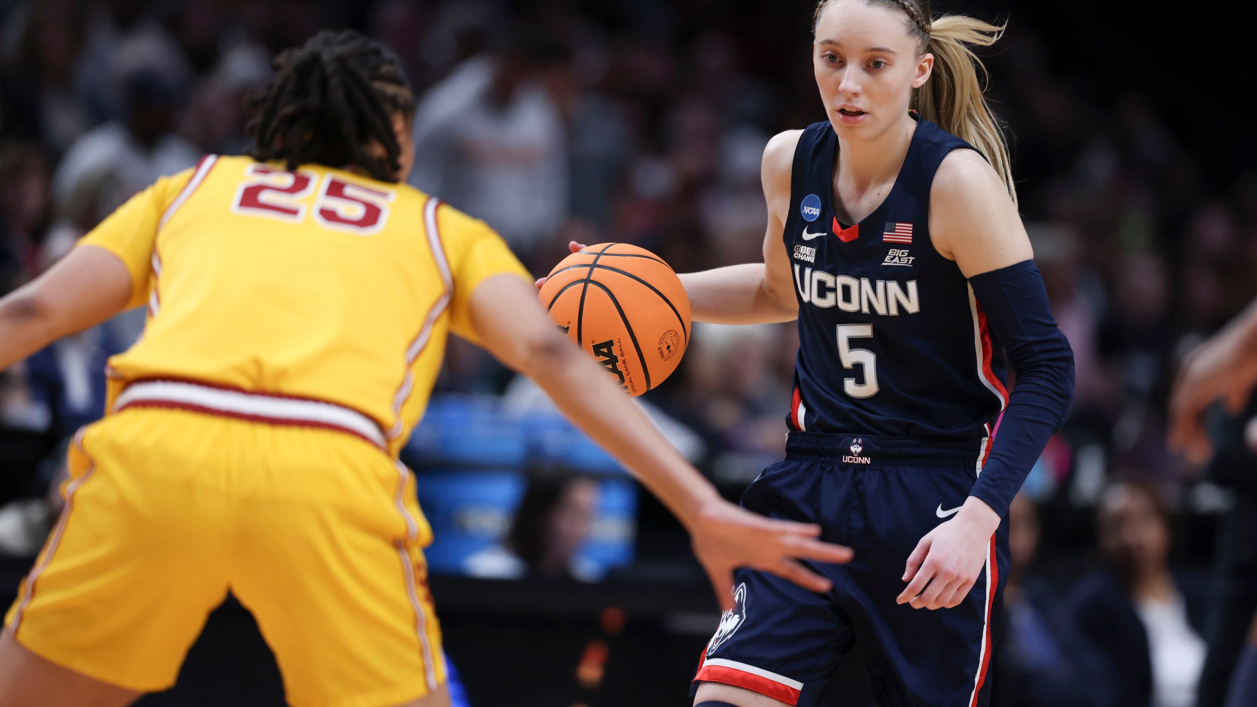 UConn guard Paige Bueckers (5) dribbles the ball as Southern California guard McKenzie Forbes (25) defends during the first half of an Elite Eight college basketball game in the women's NCAA Tournament, Monday, April 1, 2024, in Portland, Ore. (AP Photo/Howard Lao)