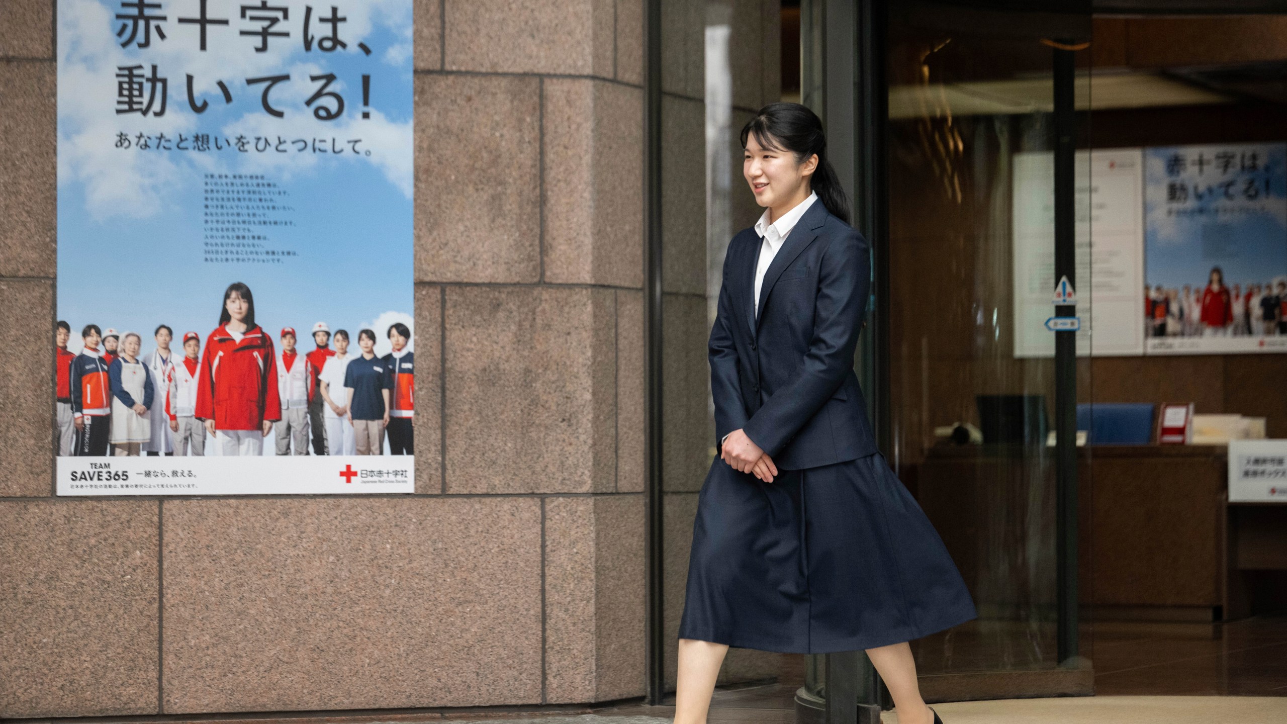Japan's Princess Aiko, the daughter of Emperor Naruhito and Empress Masako, walks out of the gate of the Japanese Red Cross Society as she begins to work on Monday, April 1, 2024. (Yuichi Yamazaki/Pool Photo via AP)