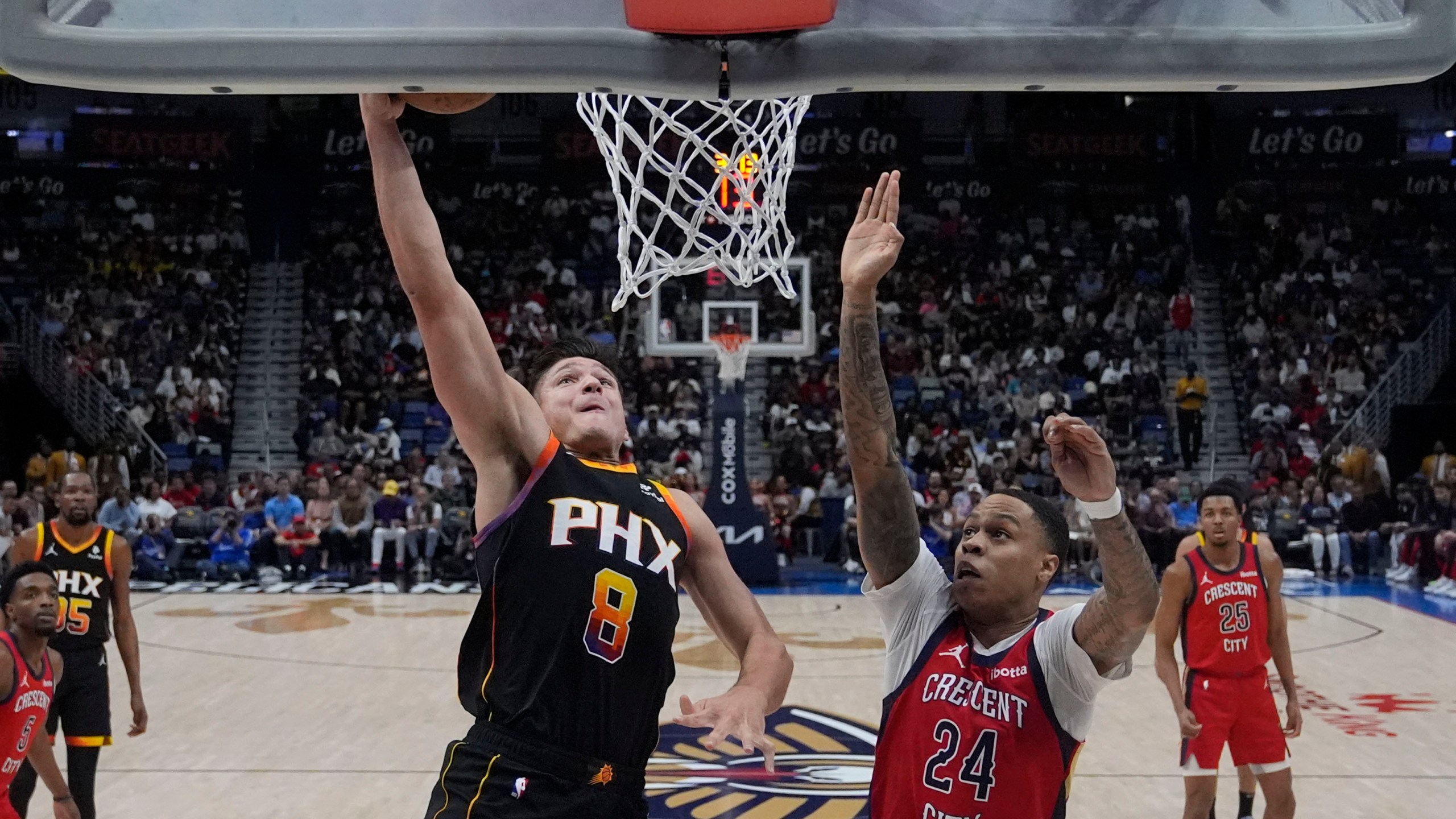 Phoenix Suns guard Grayson Allen (8) goes to the basket against New Orleans Pelicans guard Jordan Hawkins (24) in the first half of an NBA basketball game in New Orleans, Monday, April 1, 2024. (AP Photo/Gerald Herbert)