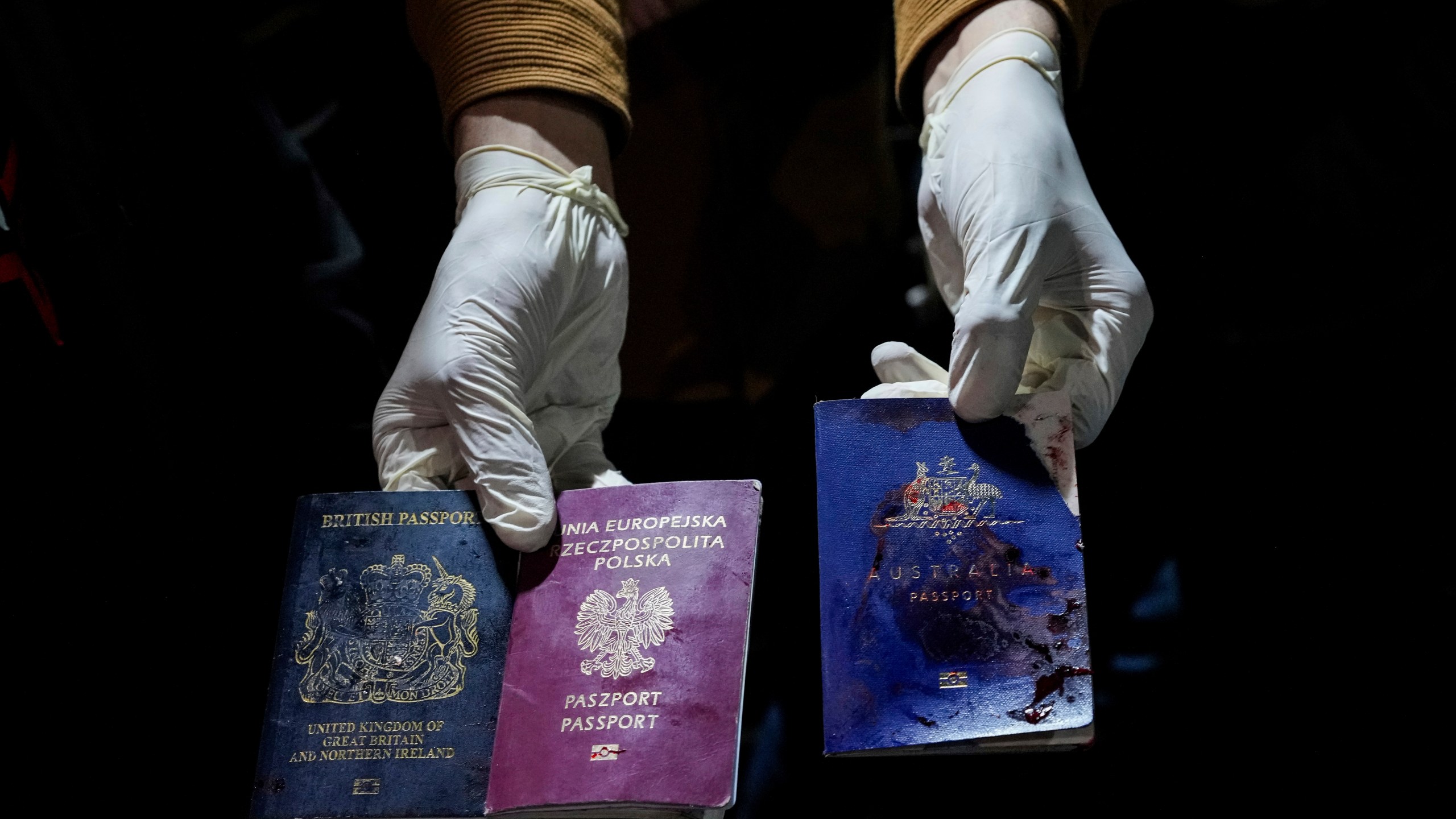 A man displays blood-stained British, Polish, and Australian passports after an Israeli airstrike, in Deir al-Balah, Gaza Strip, Monday, April 1, 2024. Gaza medical officials say an apparent Israeli airstrike killed four international aid workers with the World Central Kitchen charity and their Palestinian driver after they helped deliver food and other supplies to northern Gaza that had arrived hours early by ship. (AP Photo/Abdel Kareem Hana)