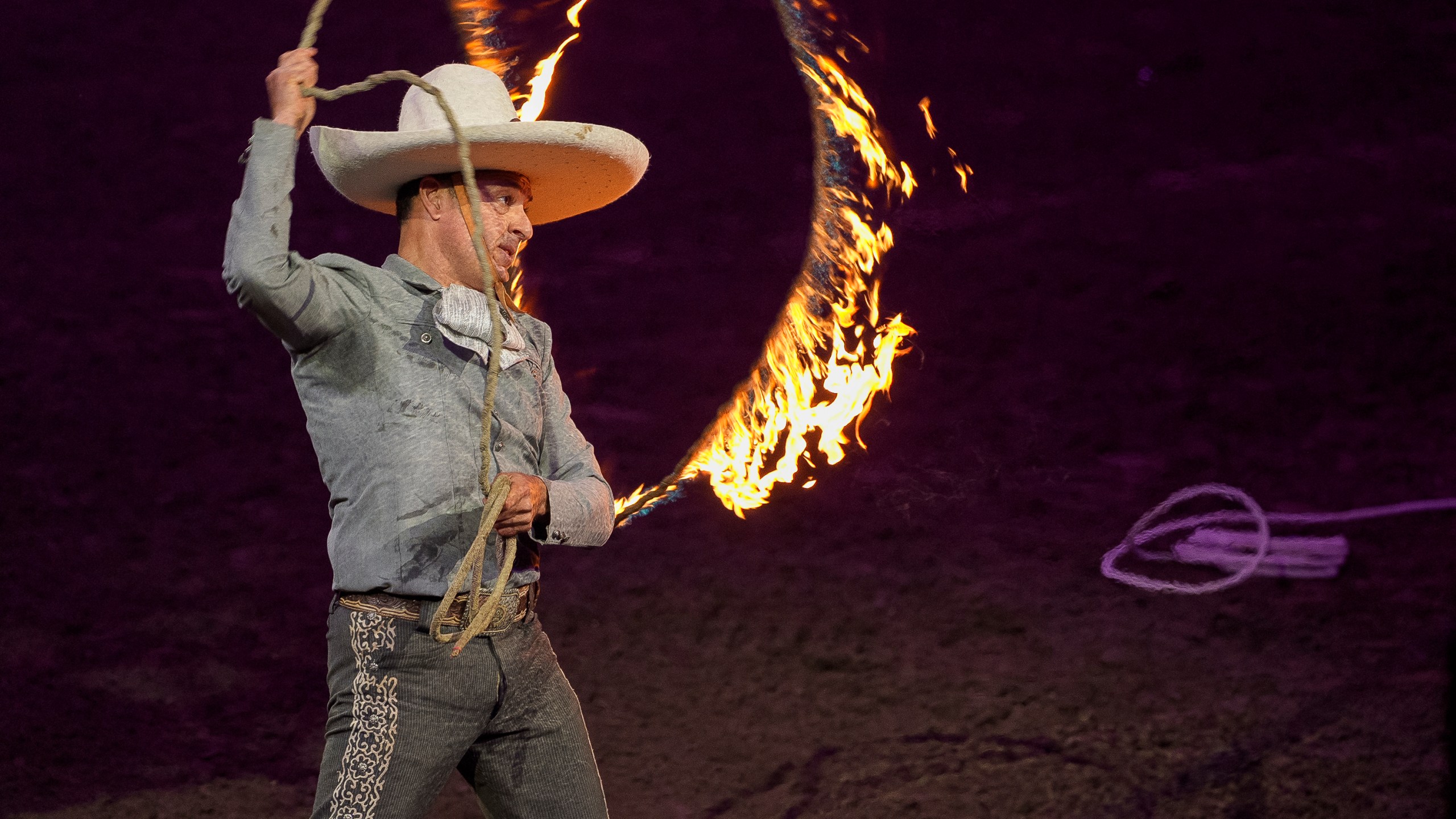 Luis Miguel Rivera performs tricks with a rope in fire at the "Jaripeo Hasta Los Huesos Tour 2024" show at the Honda Center in Anaheim, Calif., on Friday, March 29, 2024. The Grammy-winning singer songwriter Pepe Aguilar show pays tribute to the Day of the Dead, a well-known Mexican celebration. (AP Photo/Damian Dovarganes)