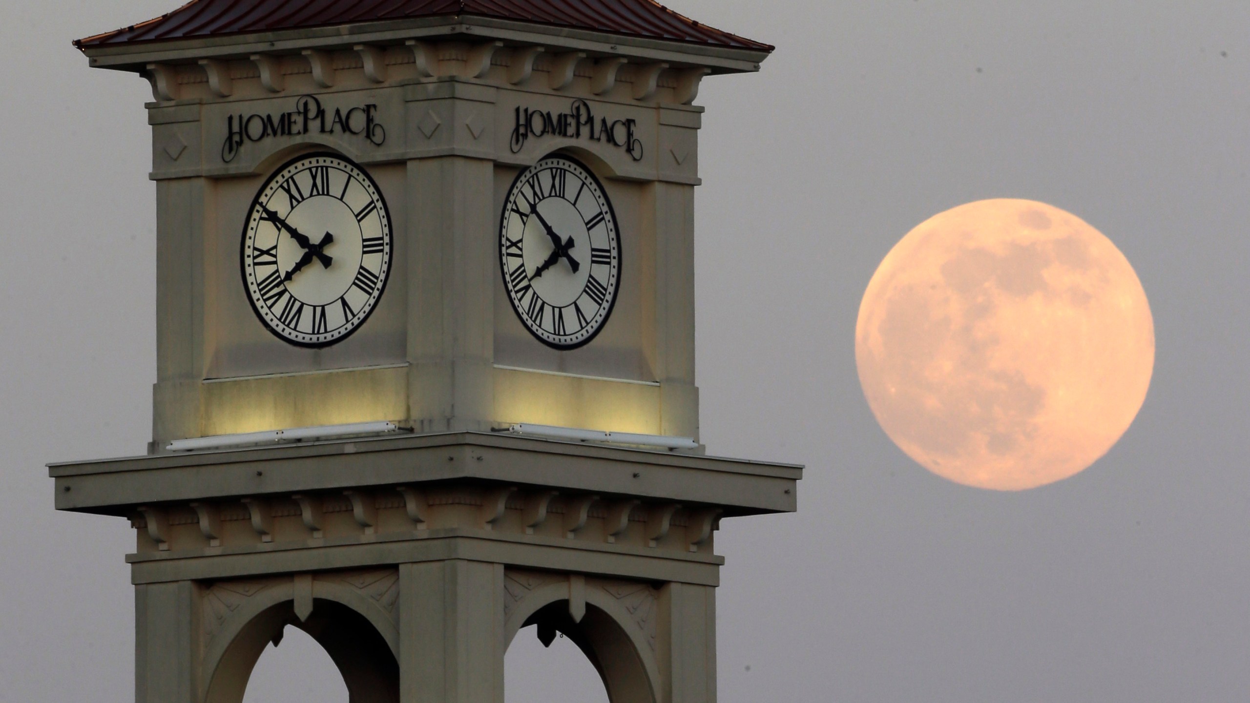 FILE - The moon rises behind the Home Place clock tower in Prattville, Ala., Saturday, June 22, 2013. NASA wants to come up with an out-of-this-world way to keep track of time, putting the moon on its own souped-up clock. The White House on Tuesday, April 2, 2204, told NASA to work with other agencies abroad to come up with a new moon-centric time reference system. (AP Photo/Dave Martin, File)