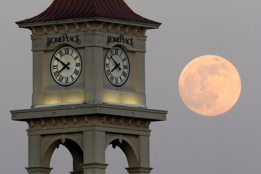 FILE - The moon rises behind the Home Place clock tower in Prattville, Ala., Saturday, June 22, 2013. NASA wants to come up with an out-of-this-world way to keep track of time, putting the moon on its own souped-up clock. The White House on Tuesday, April 2, 2204, told NASA to work with other agencies abroad to come up with a new moon-centric time reference system. (AP Photo/Dave Martin, File)