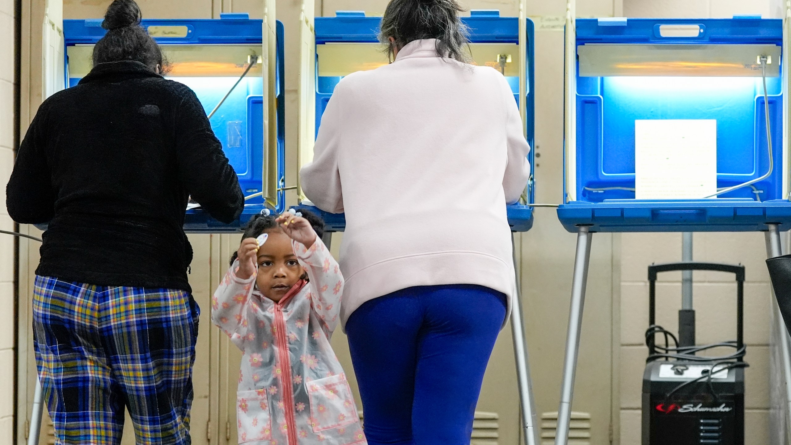 Three-year old- K-Lee waits as her mother Heather Ramsey votes during the Spring election Tuesday, April 2, 2024, in Milwaukee, Wis. (AP Photo/Morry Gash)
