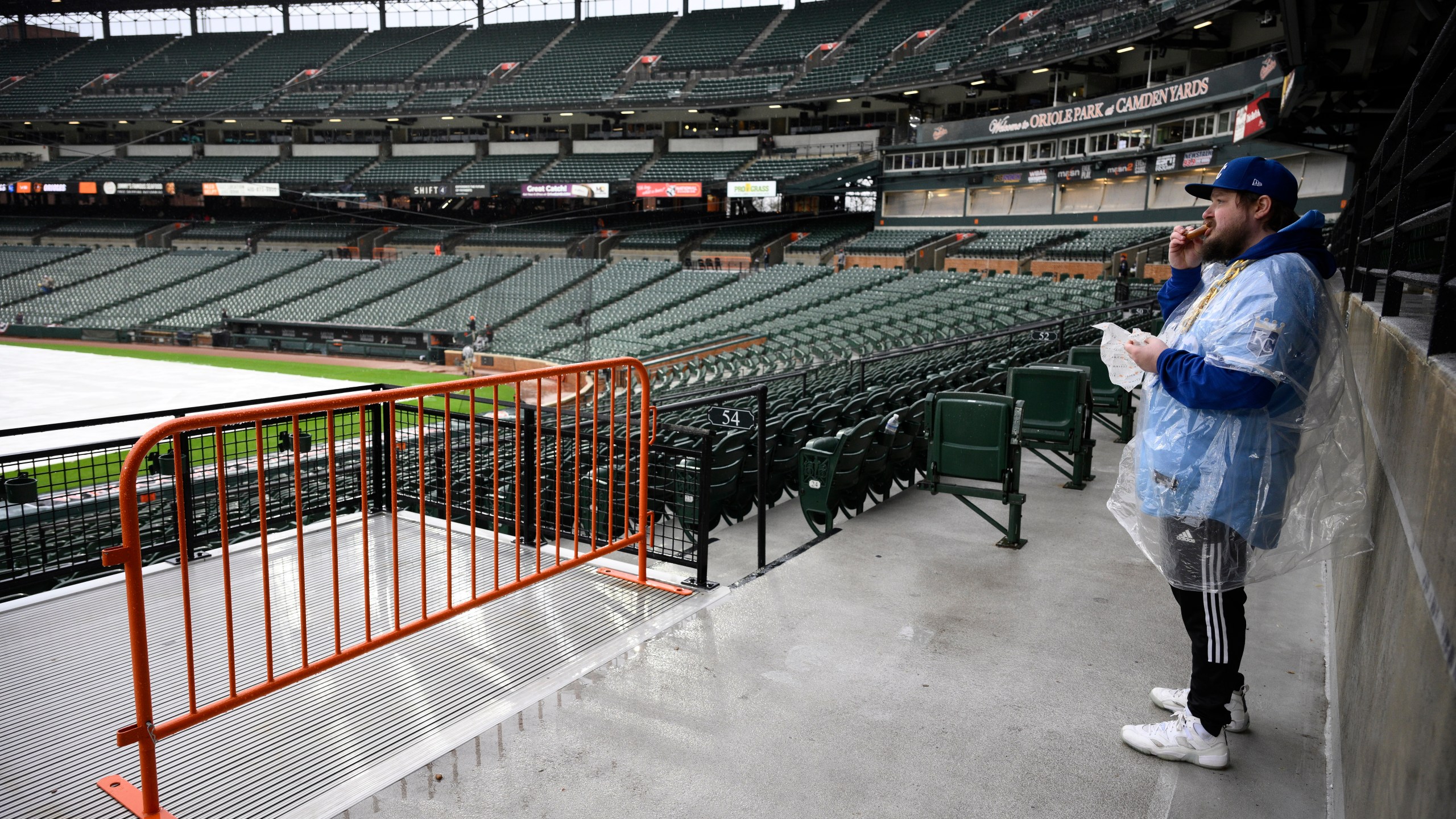 Charlie Slaybaugh of Kansas City, Mo., waits out a rain delay before a baseball game between the Baltimore Orioles and the Kansas City Royals, Wednesday, April 3, 2024, in Baltimore. (AP Photo/Nick Wass)