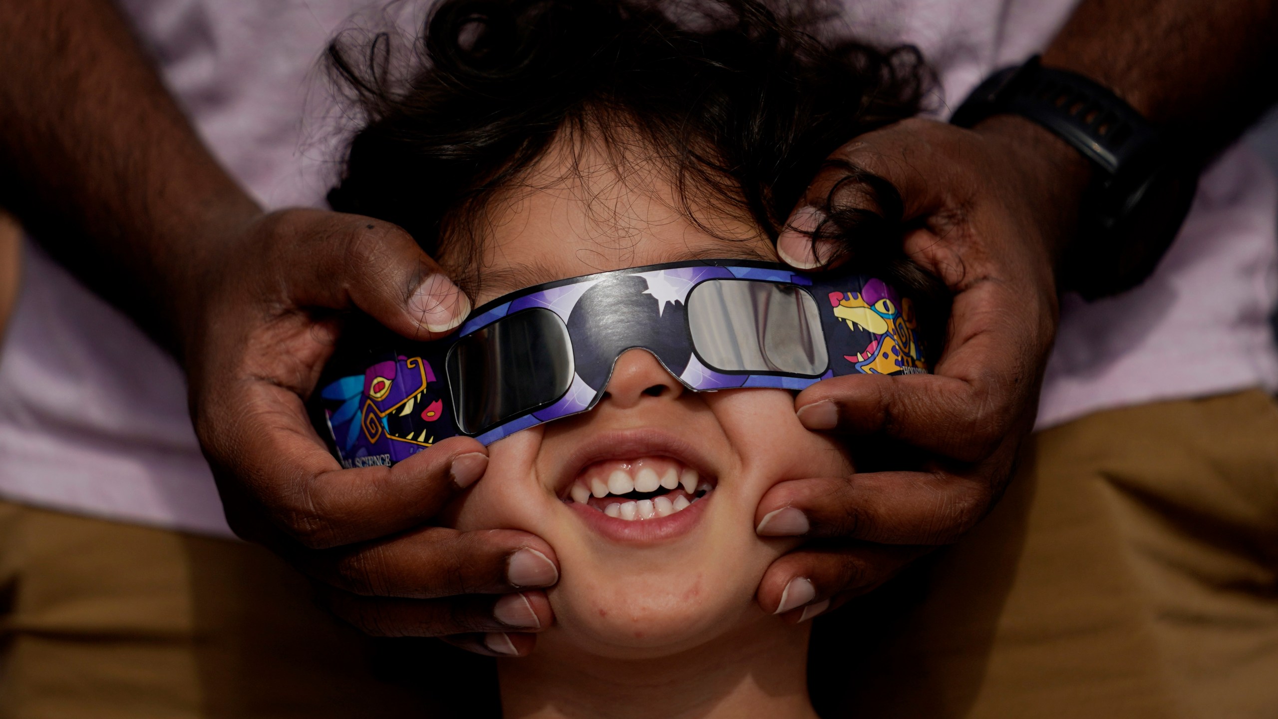 FILE - Viewers use special glasses to watch from San Antonio, as the moon moves in front of the sun during an annular solar eclipse, or ring of fire, Oct. 14, 2023. The total solar eclipse on April 8, 2024 may be weeks away but businesses are ready for the celestial event with oodles of special eclipse glasses for sale, along with T-shirts and other souvenirs. (AP Photo/Eric Gay, File)