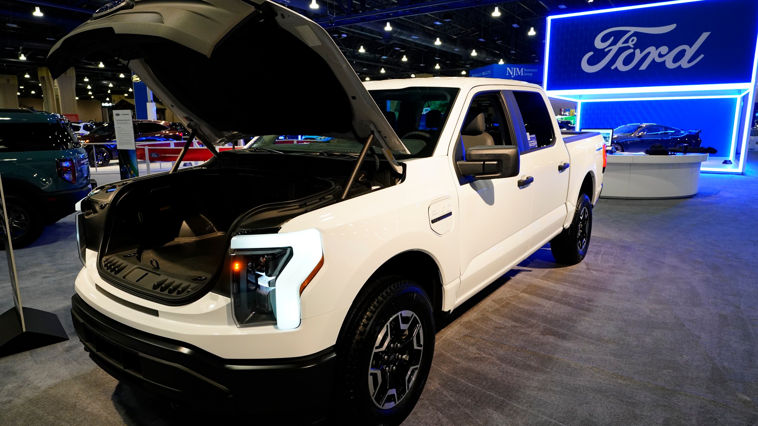 FILE - The Ford F-150 Lightning displayed at the Philadelphia Auto Show, Friday, Jan. 27, 2023, in Philadelphia. With U.S. electric vehicle sales starting to slow, Ford Motor Co. says, Thursday, April 4, 2024, it will delay rolling out new electric pickup trucks and a new large electric SUV as it adds gas-electric hybrids to its model lineup. (AP Photo/Matt Rourke, File)