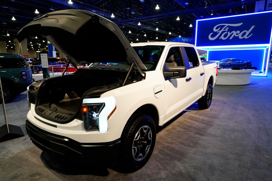 FILE - The Ford F-150 Lightning displayed at the Philadelphia Auto Show, Friday, Jan. 27, 2023, in Philadelphia. With U.S. electric vehicle sales starting to slow, Ford Motor Co. says, Thursday, April 4, 2024, it will delay rolling out new electric pickup trucks and a new large electric SUV as it adds gas-electric hybrids to its model lineup. (AP Photo/Matt Rourke, File)