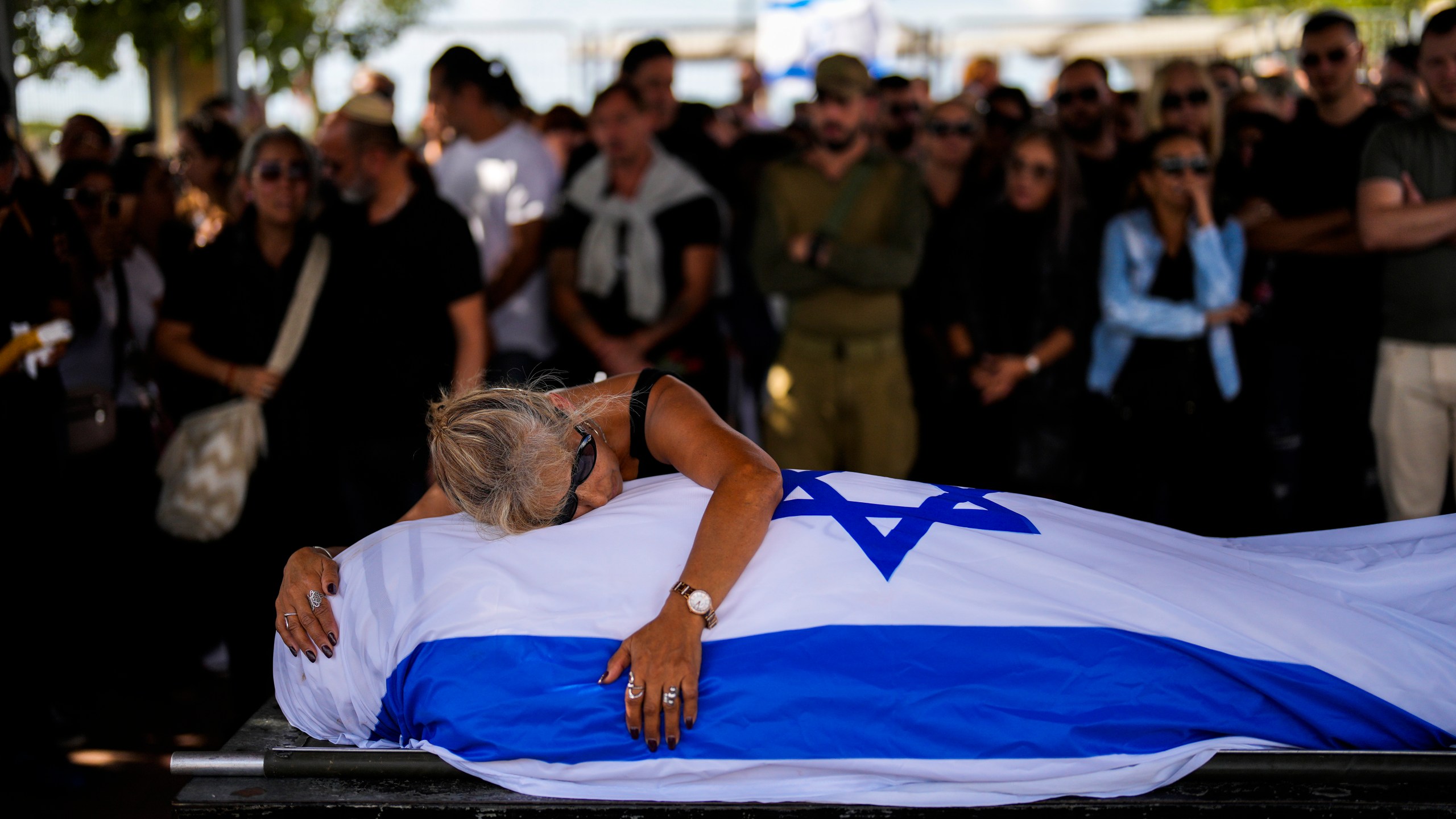 FILE - Antonio Macías' mother cries over her son's body covered with the Israeli flag at Pardes Haim cemetery in Kfar Saba, near Tel Aviv, Israel on Oct. 15, 2023. Macias was killed by Hamas militants while attending a music festival in southern Israel. (AP Photo/Francisco Seco, File)